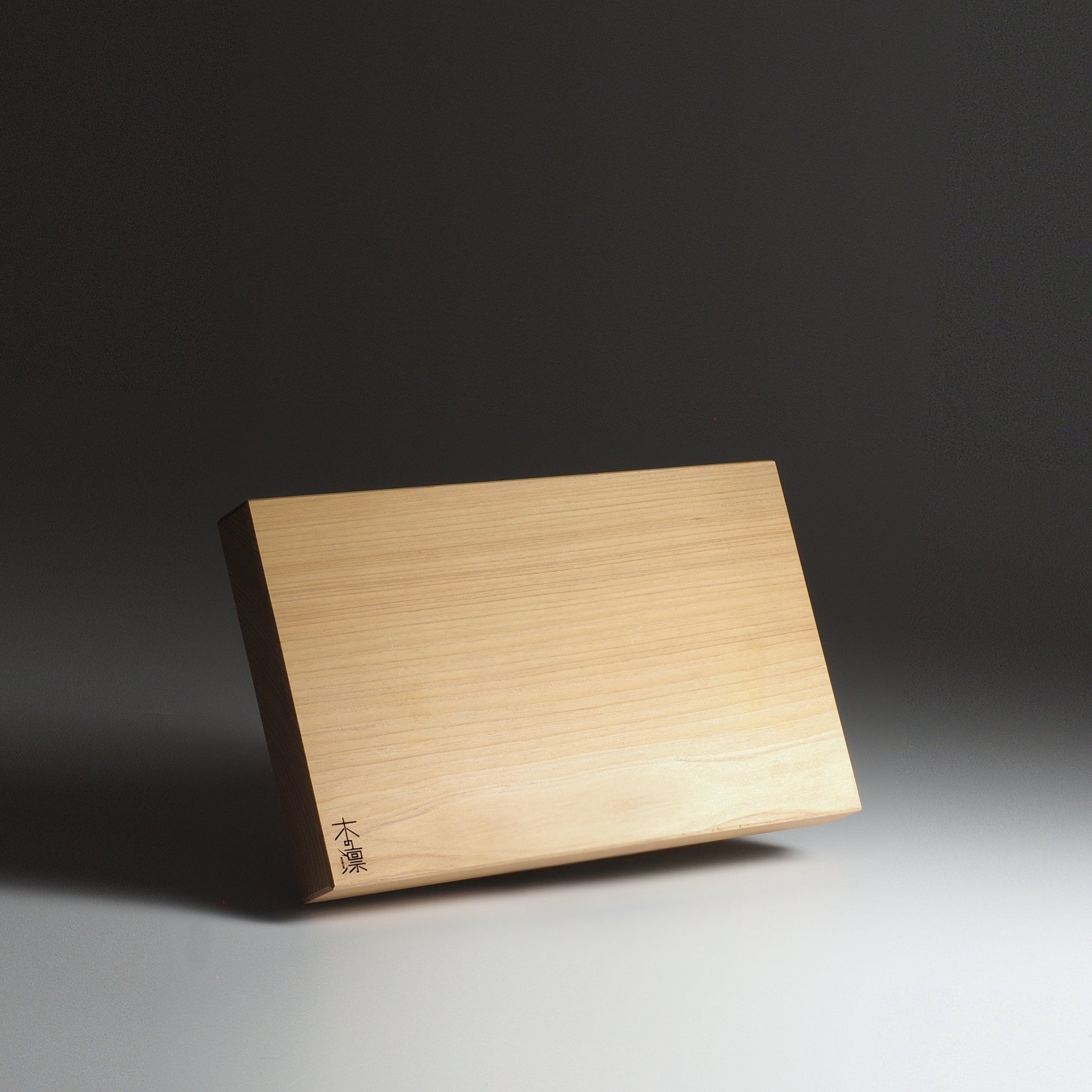 Japanese wooden cutting board, M size, with engraved text on a dark background