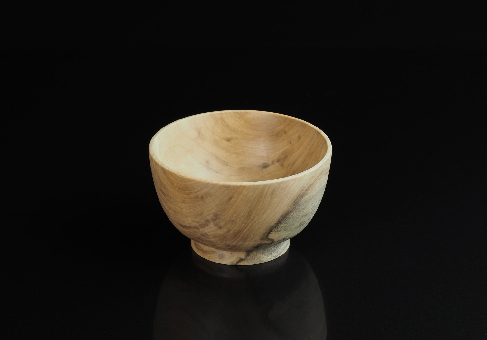 Japanese elm handcrafted wooden bowl on background black. Tsukushi
