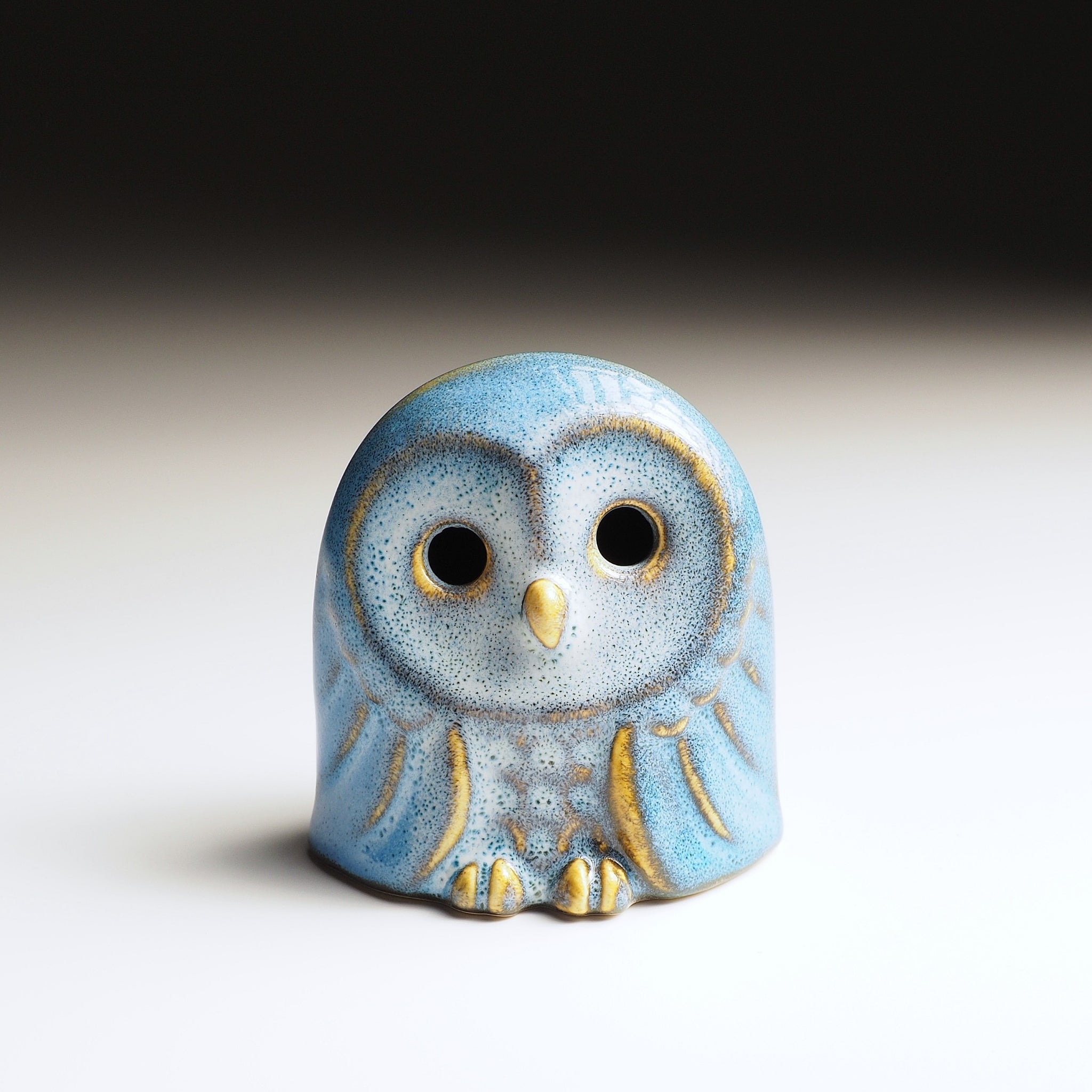 Front view of Engifuku owl figurine by Kazuhiro Kojima, blue speckled ceramic glaze, golden accents, dark eyes, gradient background.