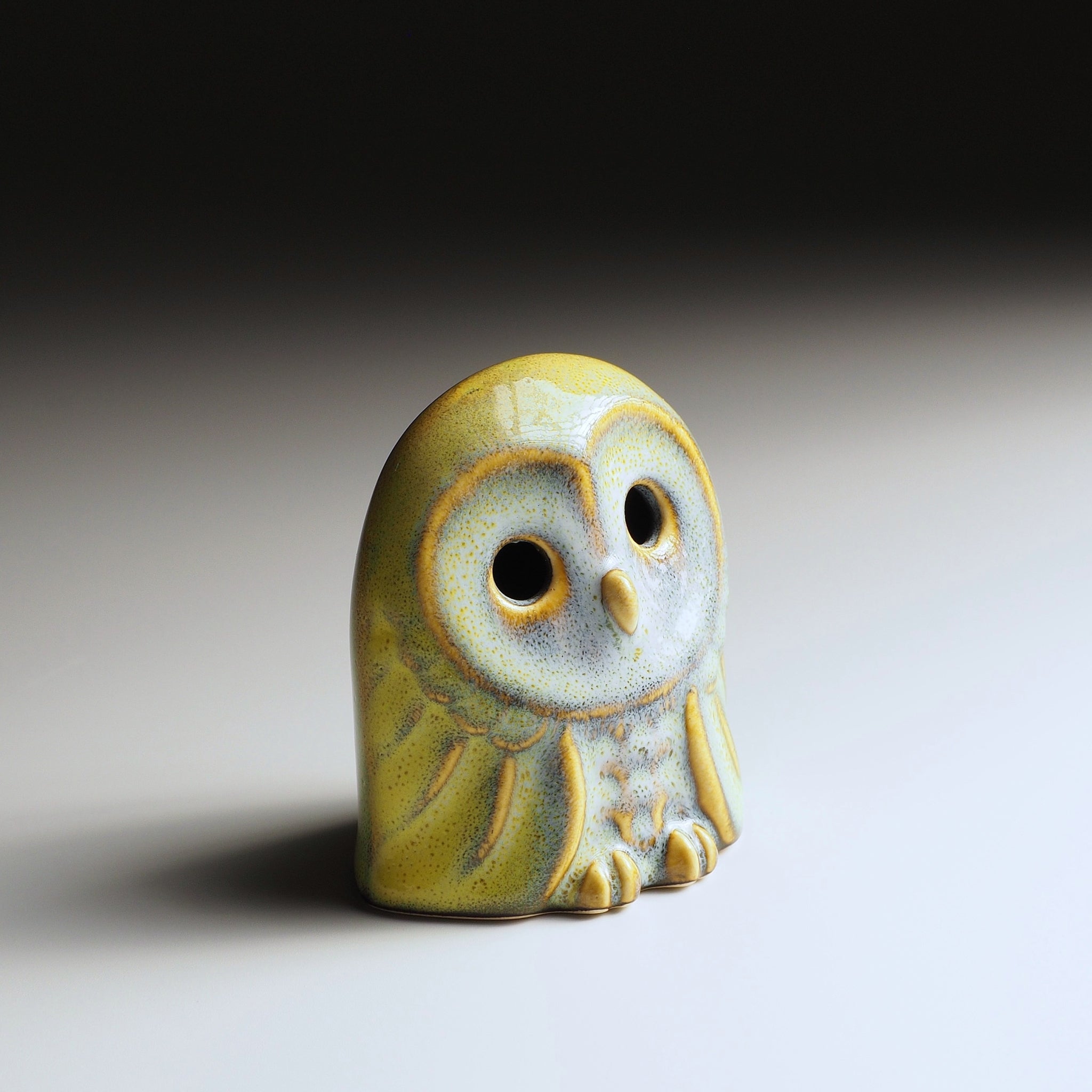 Oblique view of Engifuku owl figurine by Kazuhiro Kojima, blue speckled ceramic glaze, golden accents, hollow eyes, gradient background.
