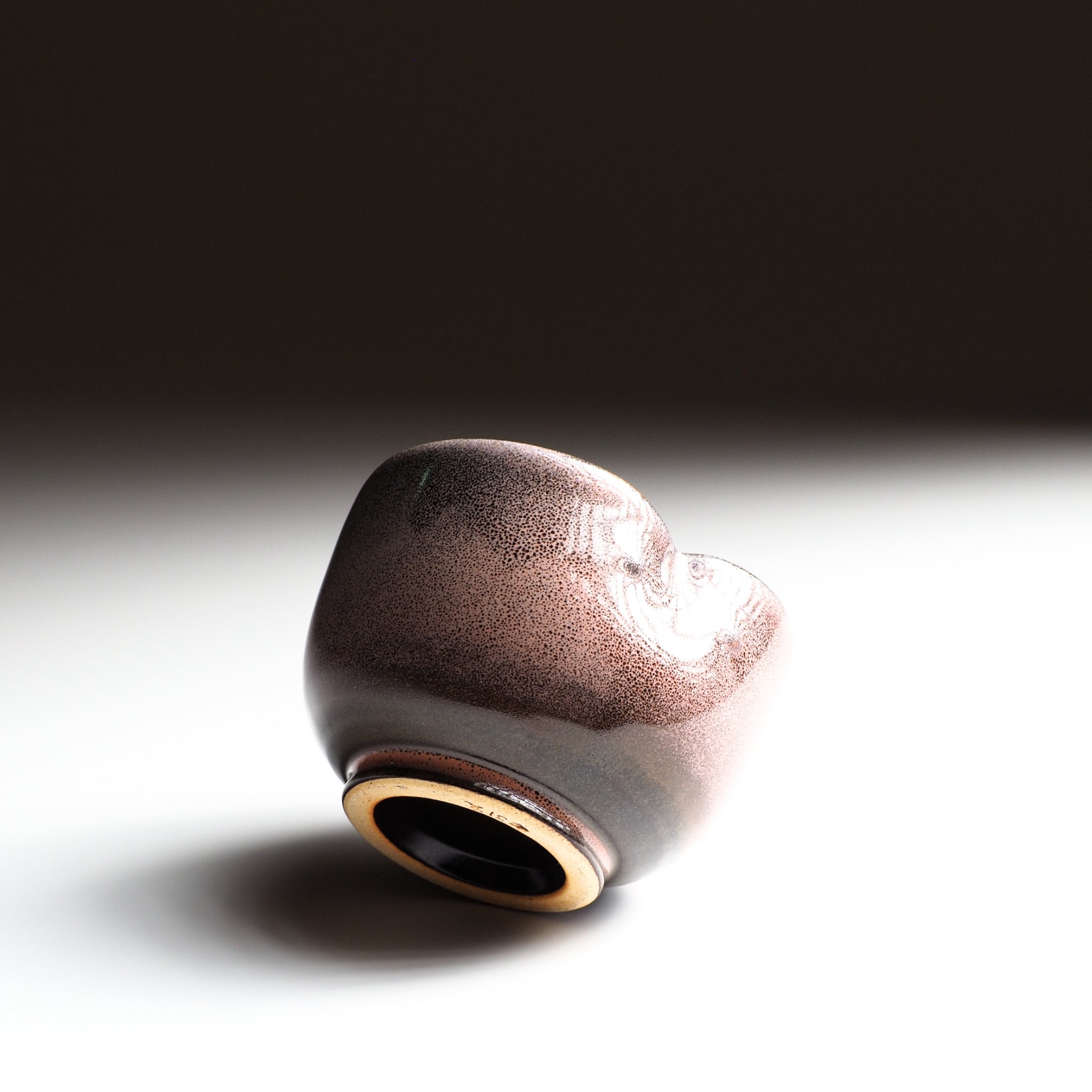 Japanese ceramic yunomi teacup with a textured surface on a gradient background