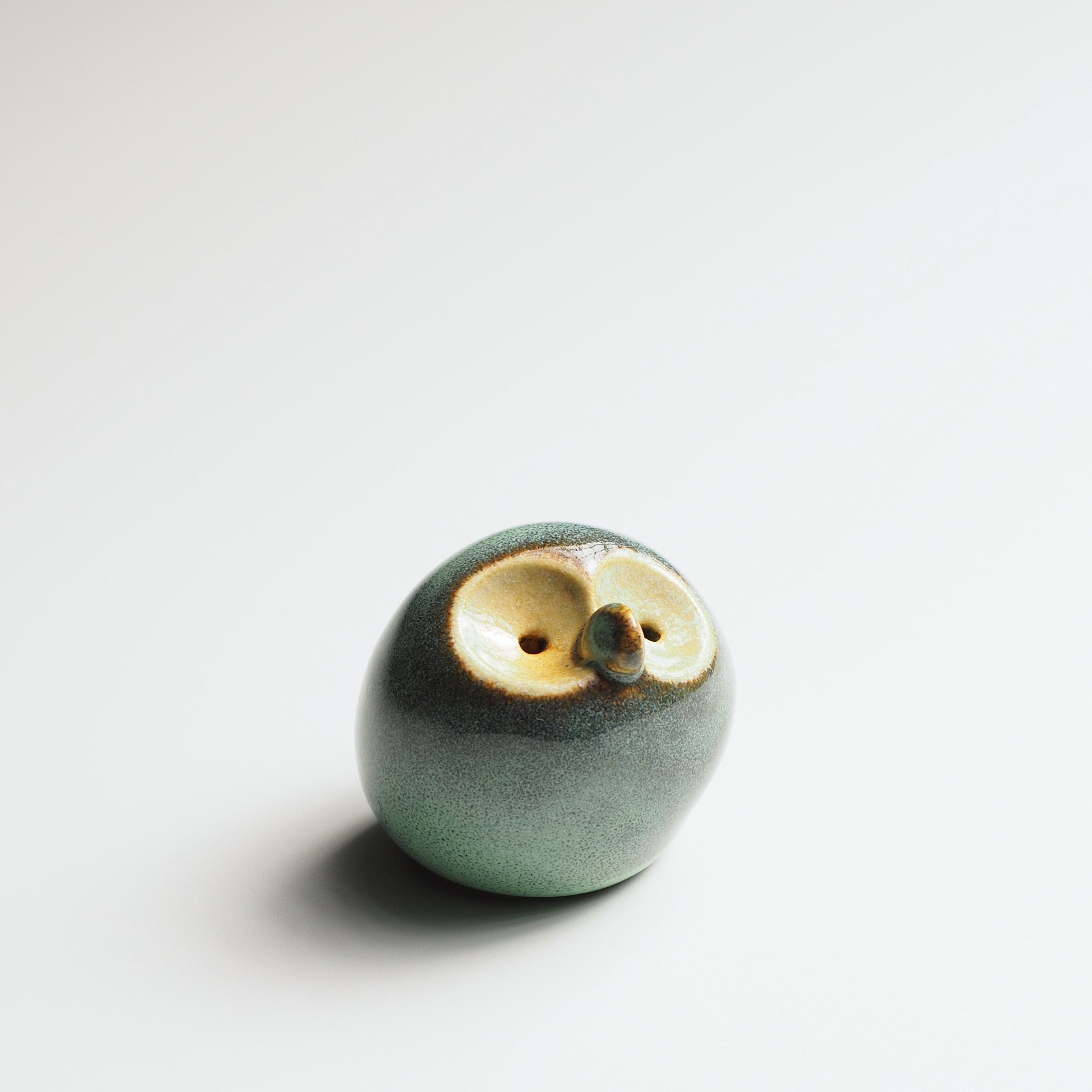 Misty celadon Gofuku ceramic owl figurine with gold-glazed face and eyes, showcasing natural glaze depth and texture.