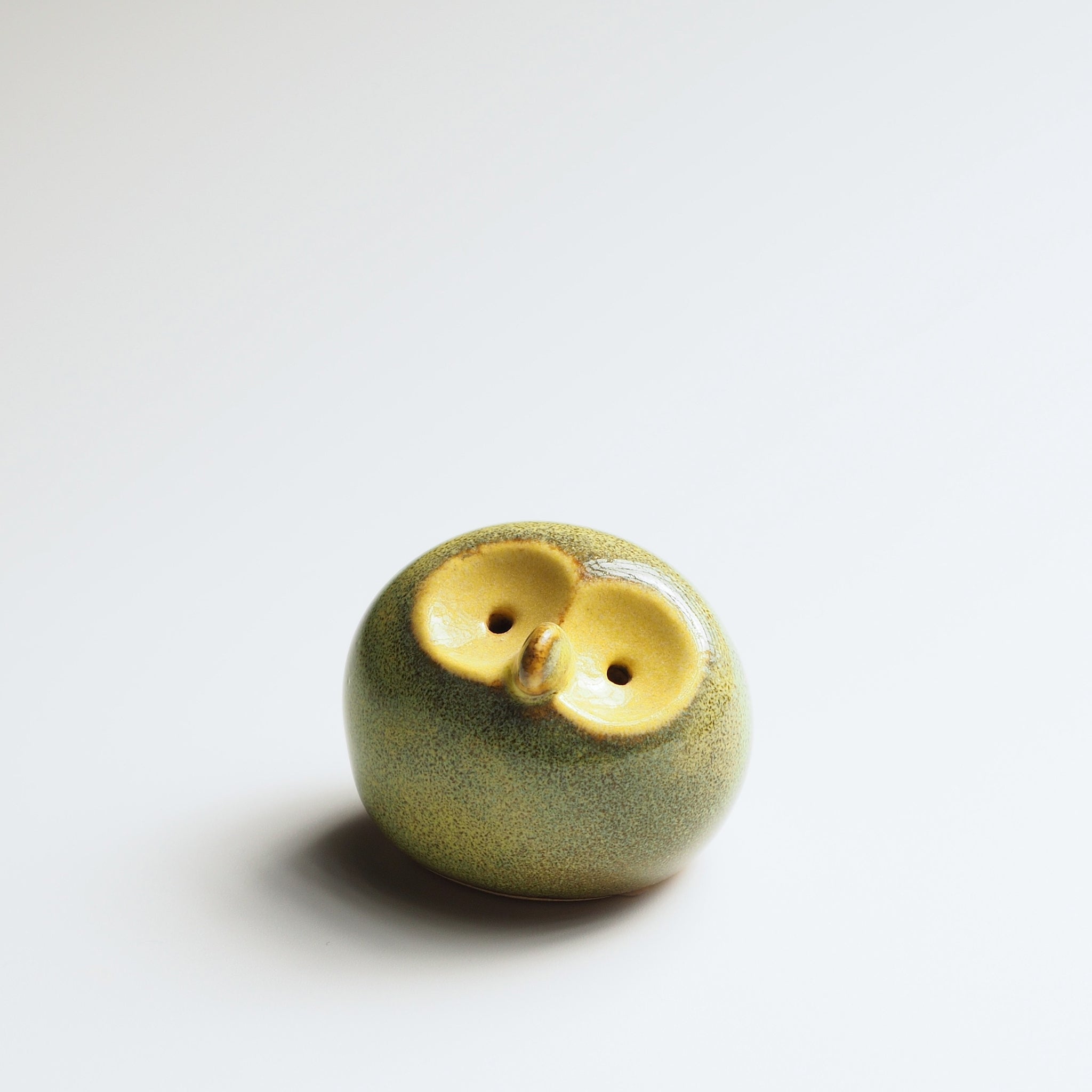 Moss chartreuse Gofuku ceramic owl figurine with gold-glazed face and eyes, detail view of textured surface finish.