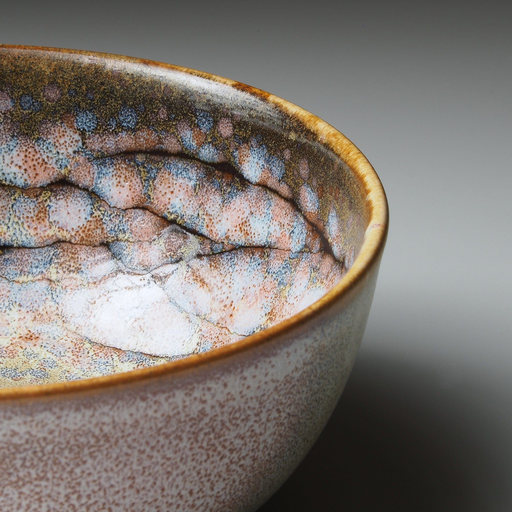 Close-up of a Japanese ceramic bowl with textured surface on a gradient background