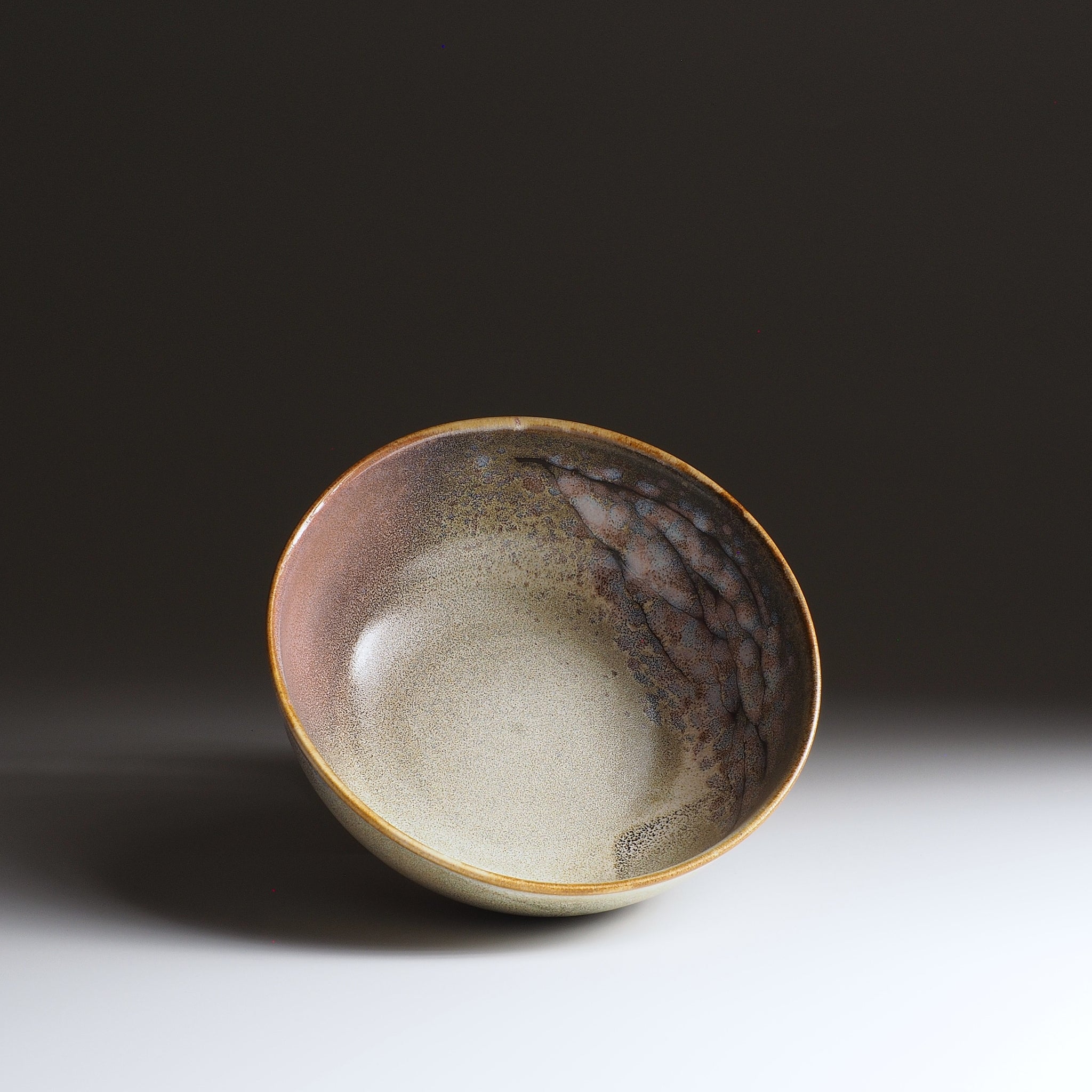 Inside view of the Harukaze Pink Cherry Blossoms salad bowl by Kazuhiro Kojima on a faded background.