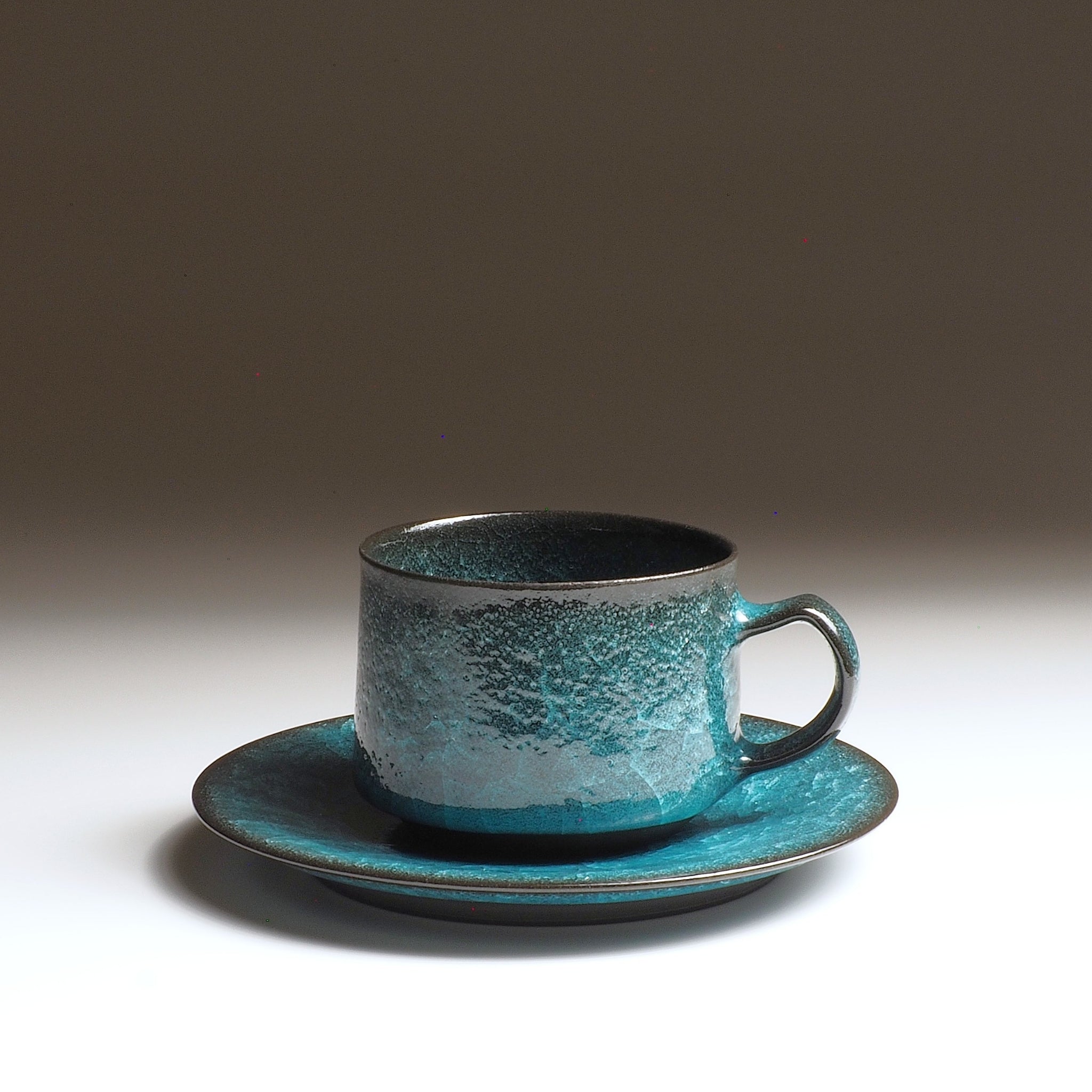Handcrafted Japanese ceramic coffee cup and saucer with kannyū crackle glaze in emerald green and deep obsidian, by Taichi Kawai, Usurai Pottery Kyoto