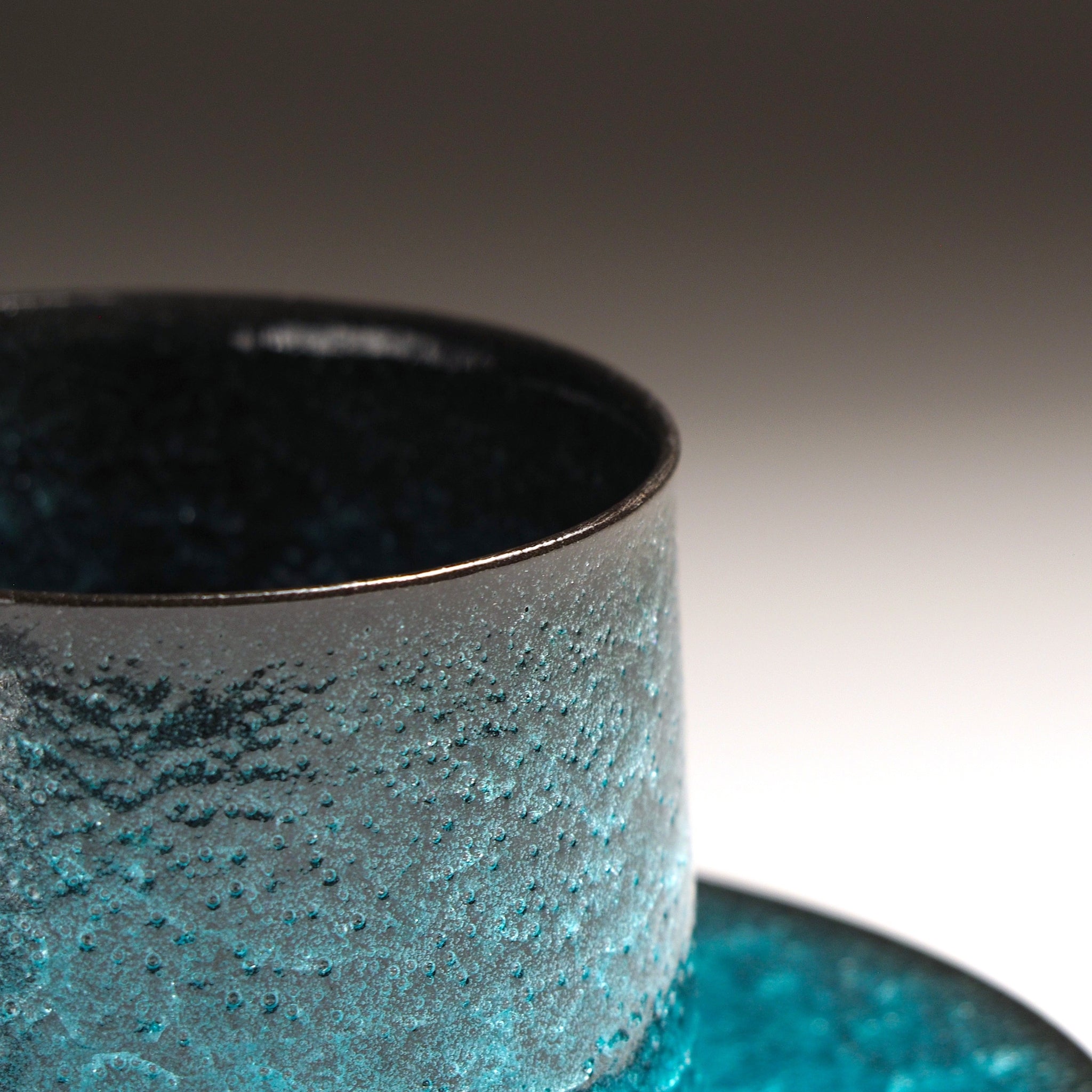 Close-up of Japanese pottery coffee cup showing kannyū ceramic crazing glaze texture, emerald green and frosted stone, Usurai Pottery Kyoto
