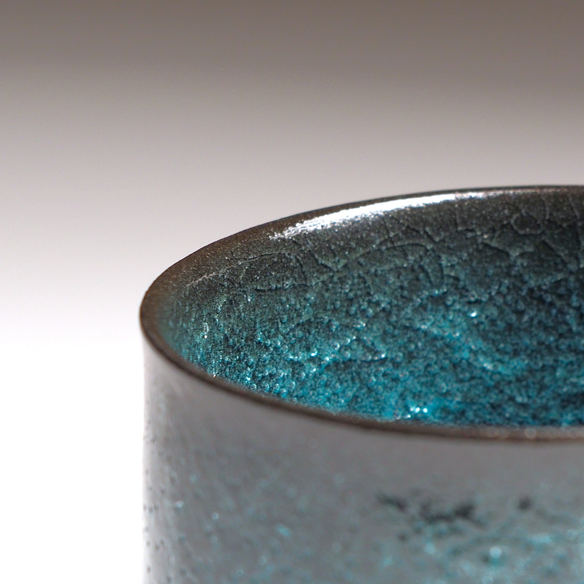 Close-up of the Seika ceramic coffee cup with a ceramic crazing green interior on a neutral background