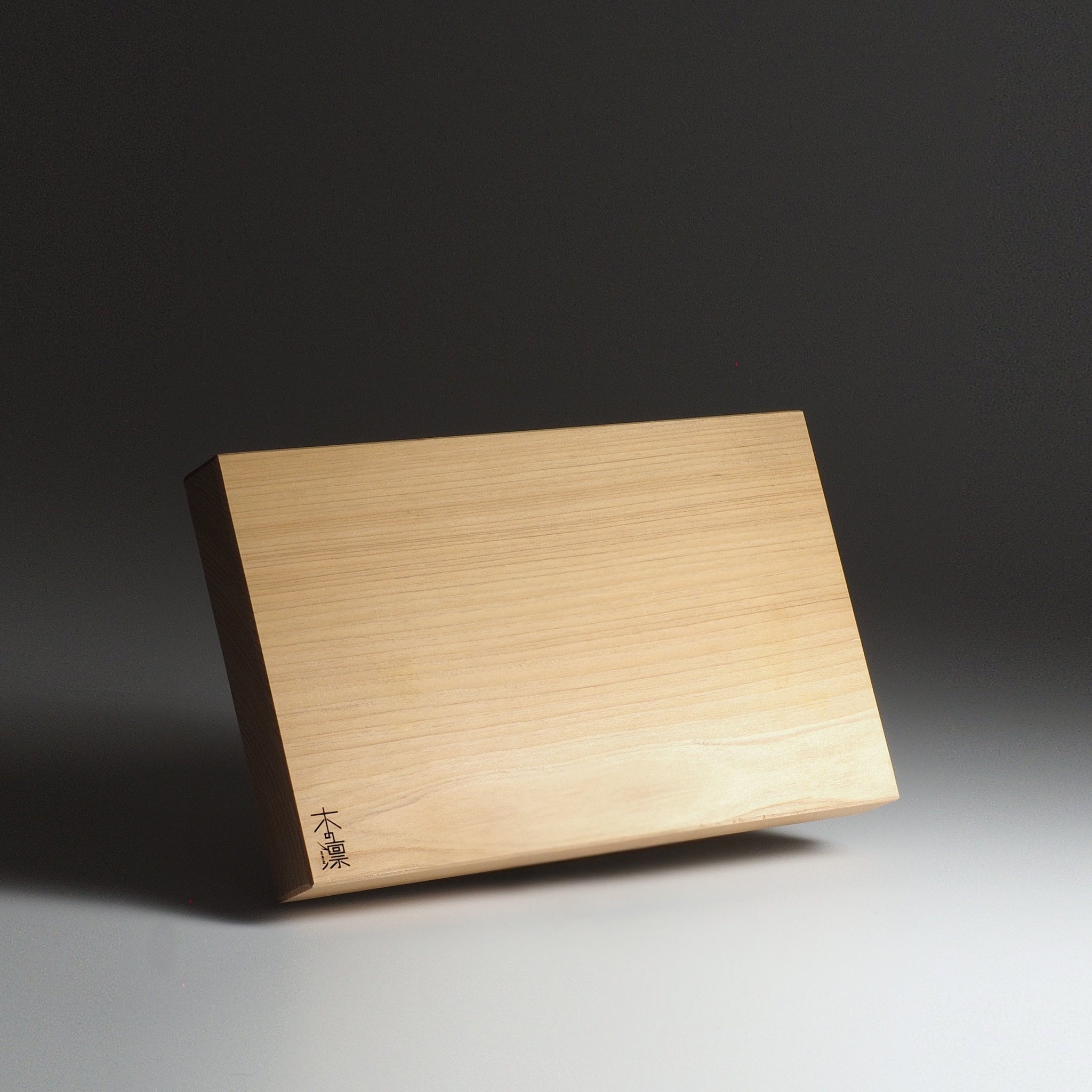 Japanese wooden cutting board, L size, with engraved text on a dark background