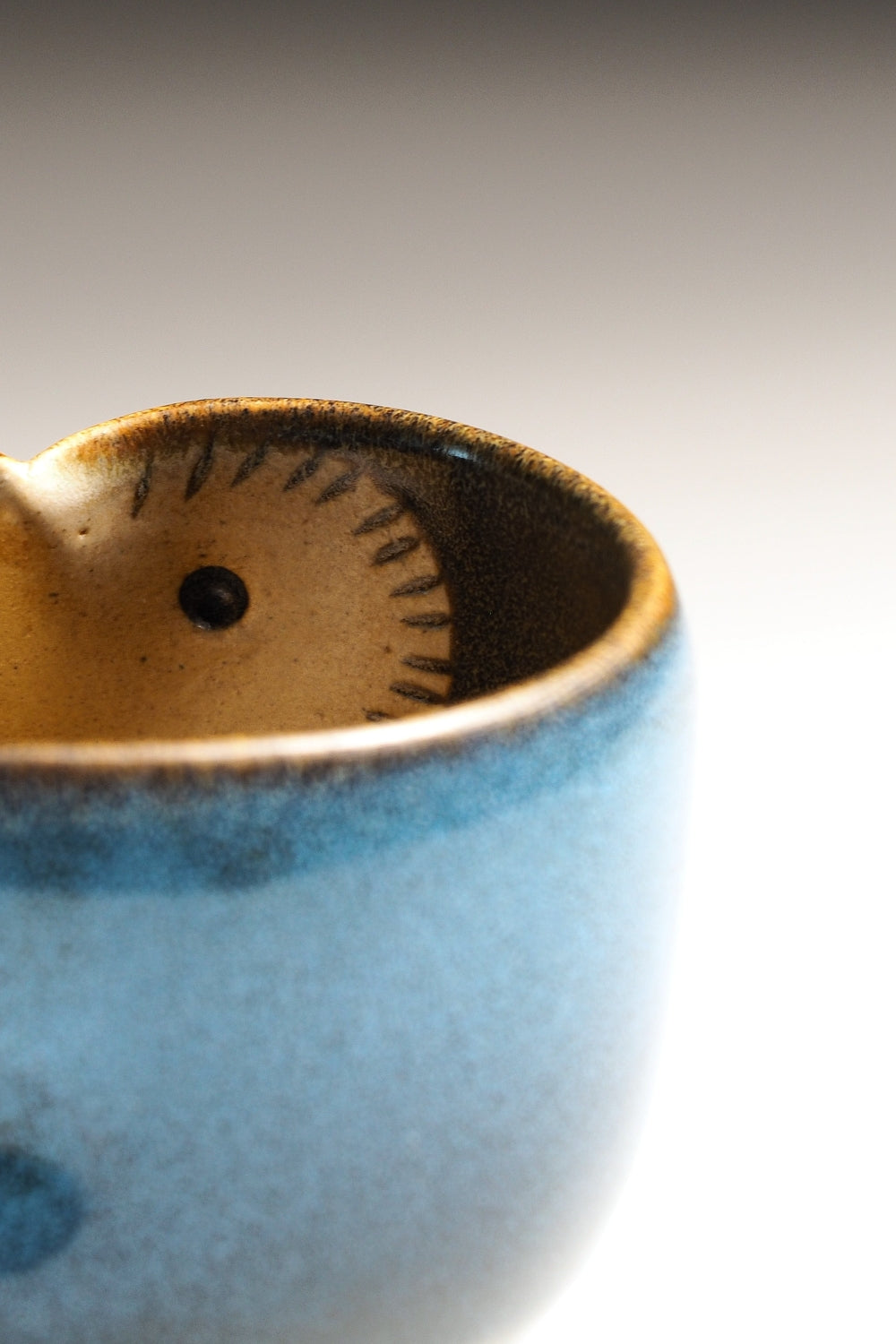 Close-up of a Japanese pottery Yunomi cup with owl motif in its inside.