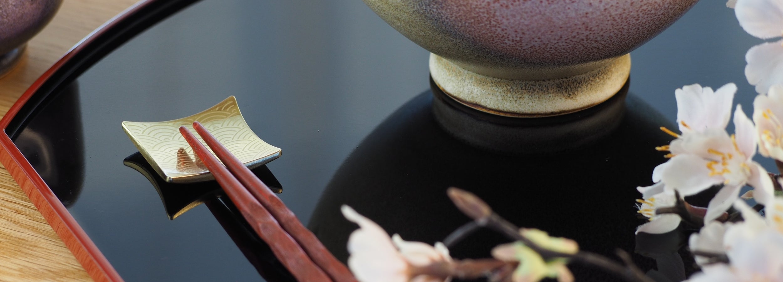 Close-up of a Japanese chopstick rest  with a Japanese ceramic rice bowl. Tsukushi