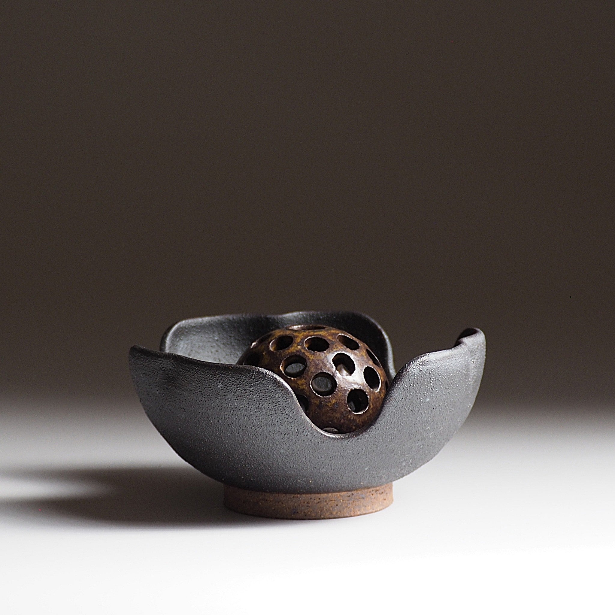 Japanese  ikebana vase with ceramic flower frog an matching bowl on a faded background. Tsukushi