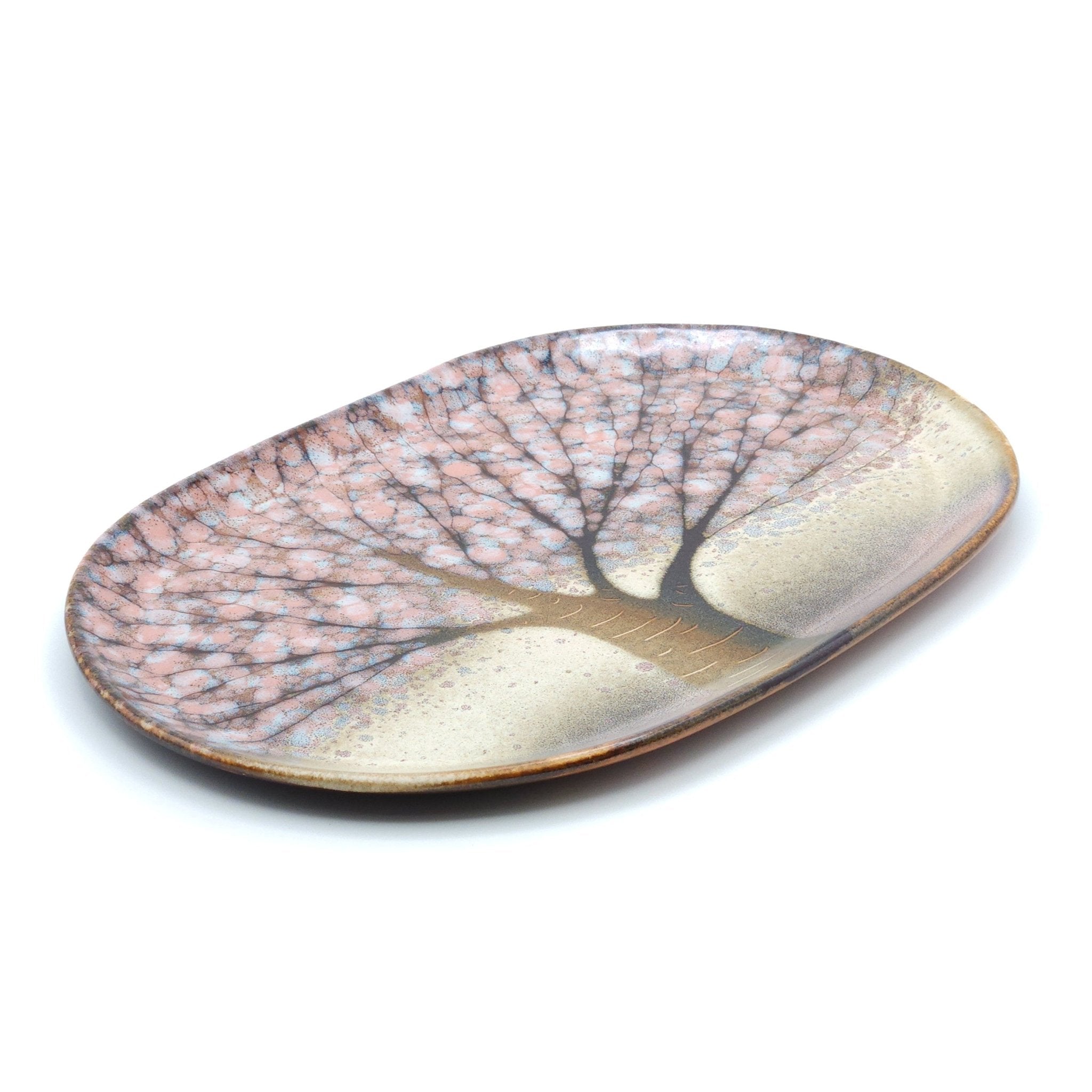Oblique view of a Japanese plate made of pottery with cherry blossoms motif in green 
