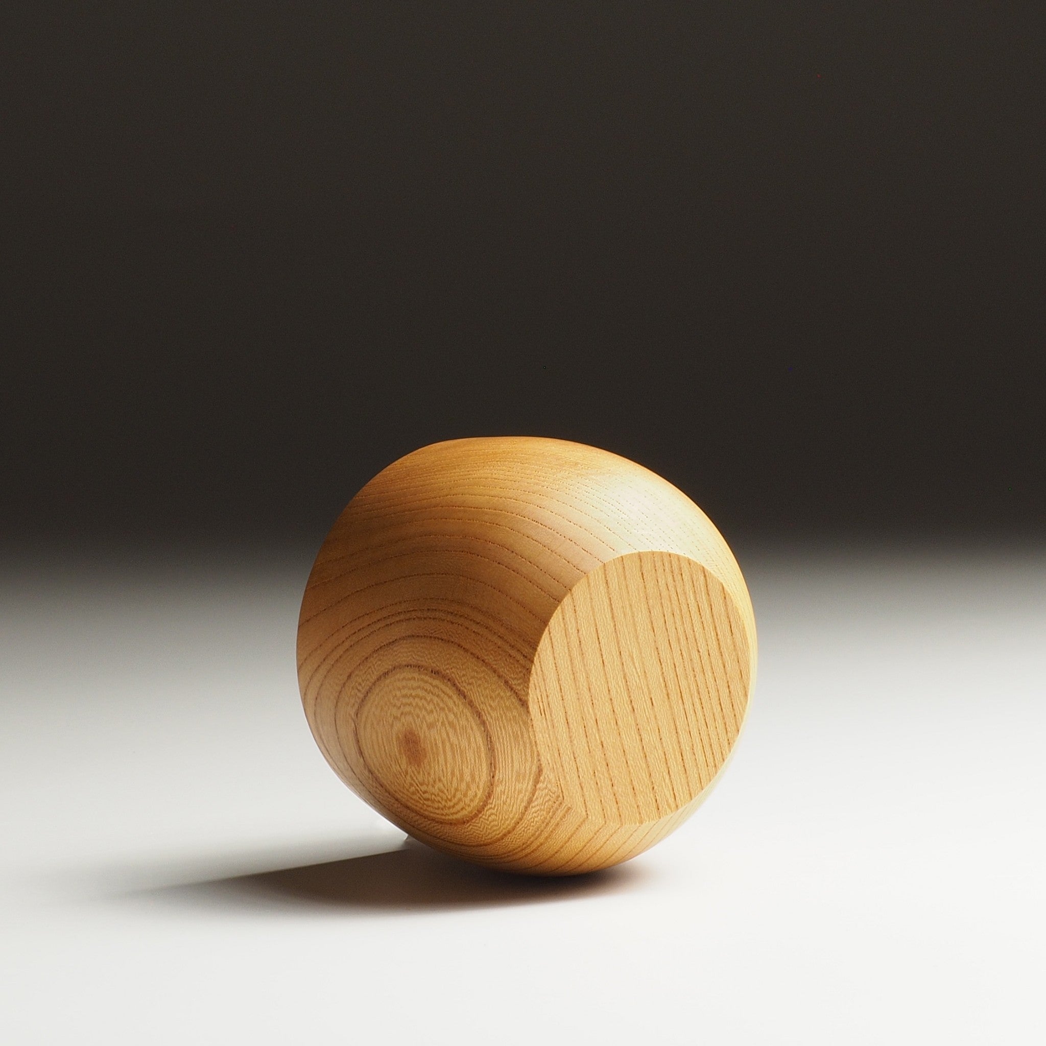A back side view of a Japanese wooden cup on a gradient background. Tsukushi