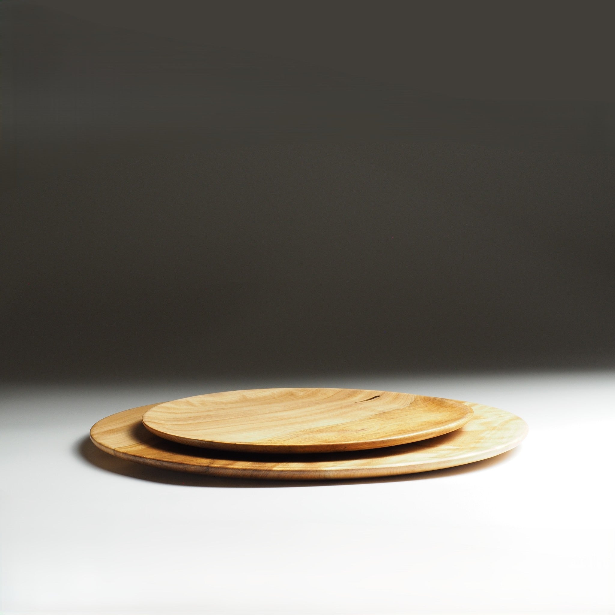 Two Japanese wood plates stacked on a dark background. Tsukushi