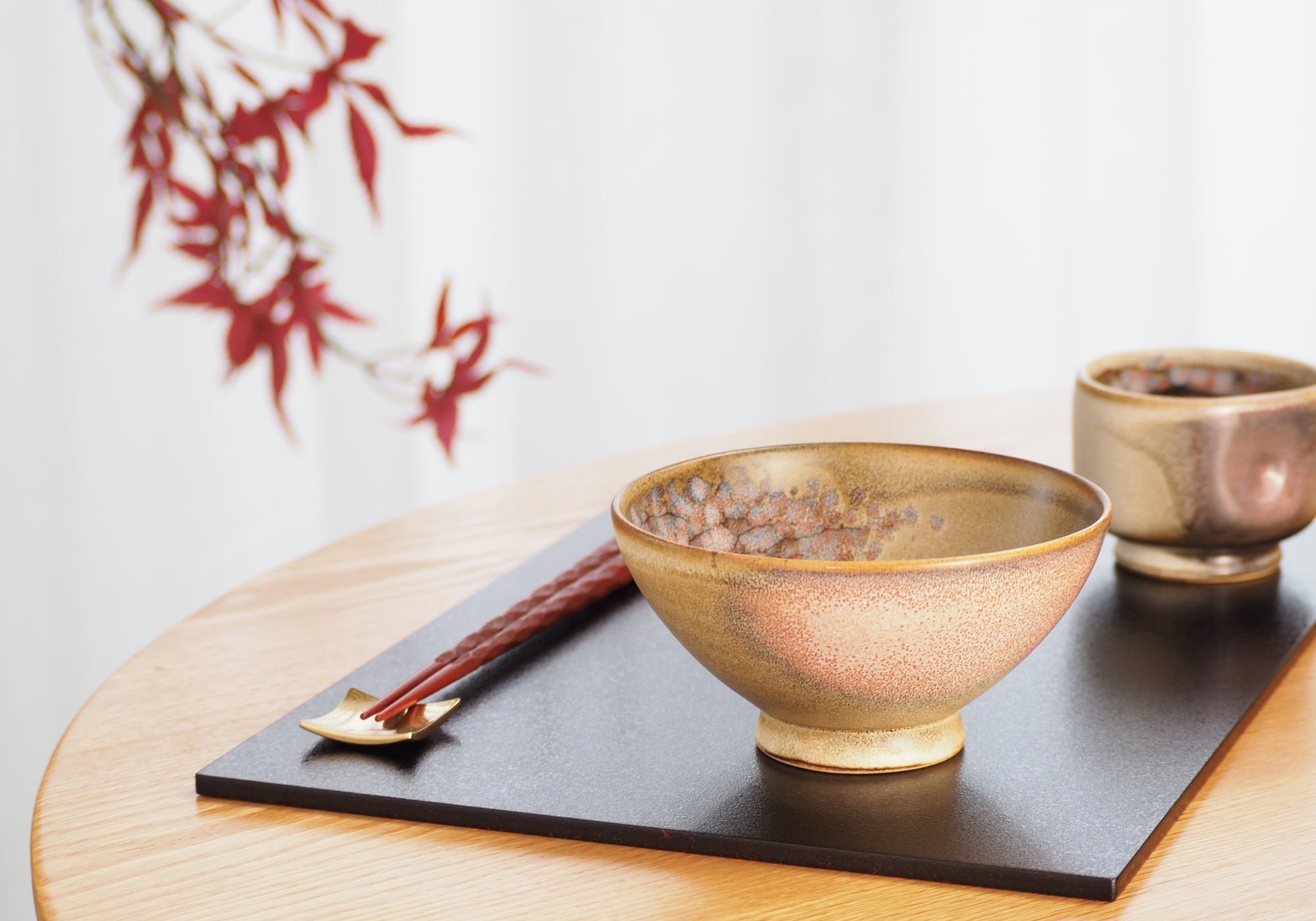 A handcrafted Japanese ceramic bowl and teacup with a cherry blossoms pattern. Tsukushi