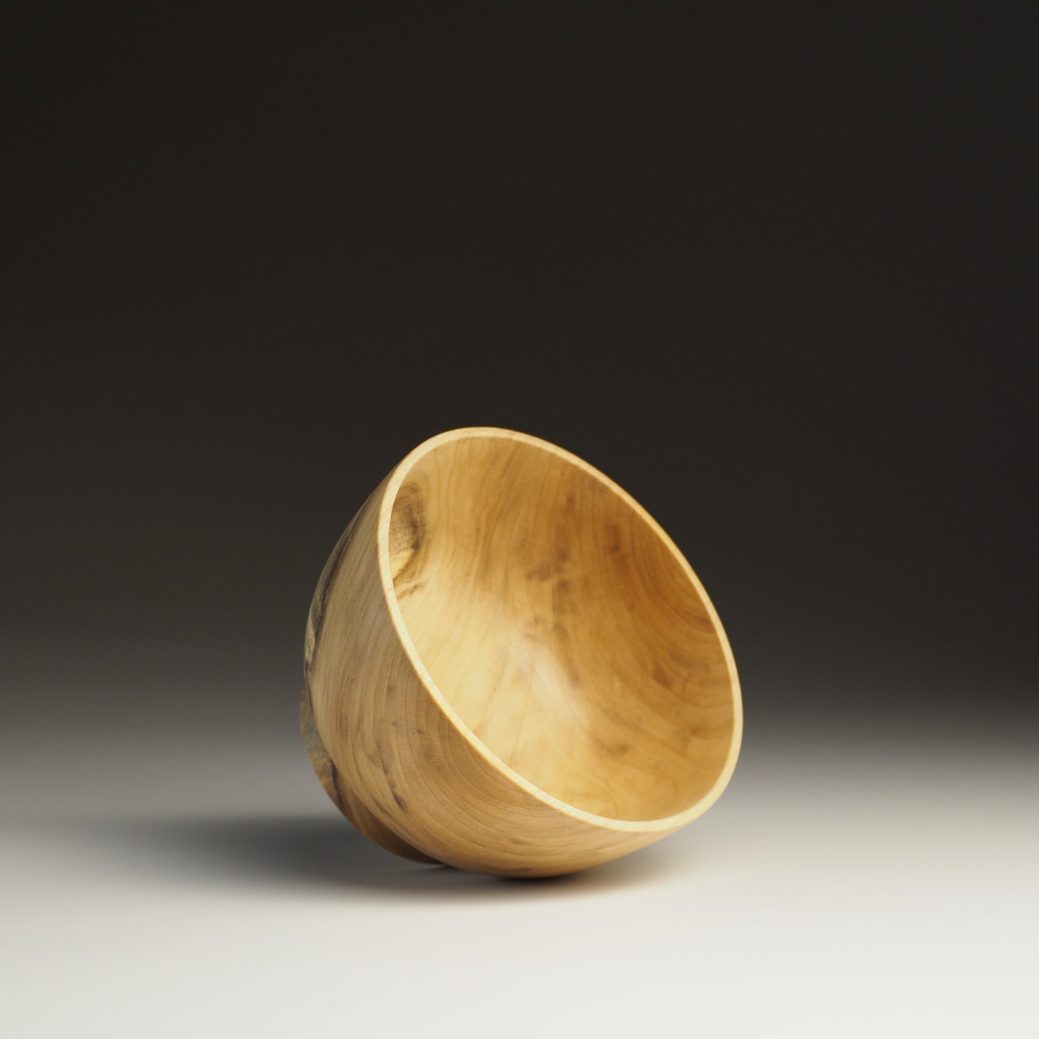 A side view of a Japanese Wooden Bowl on a black background. Tsukushi