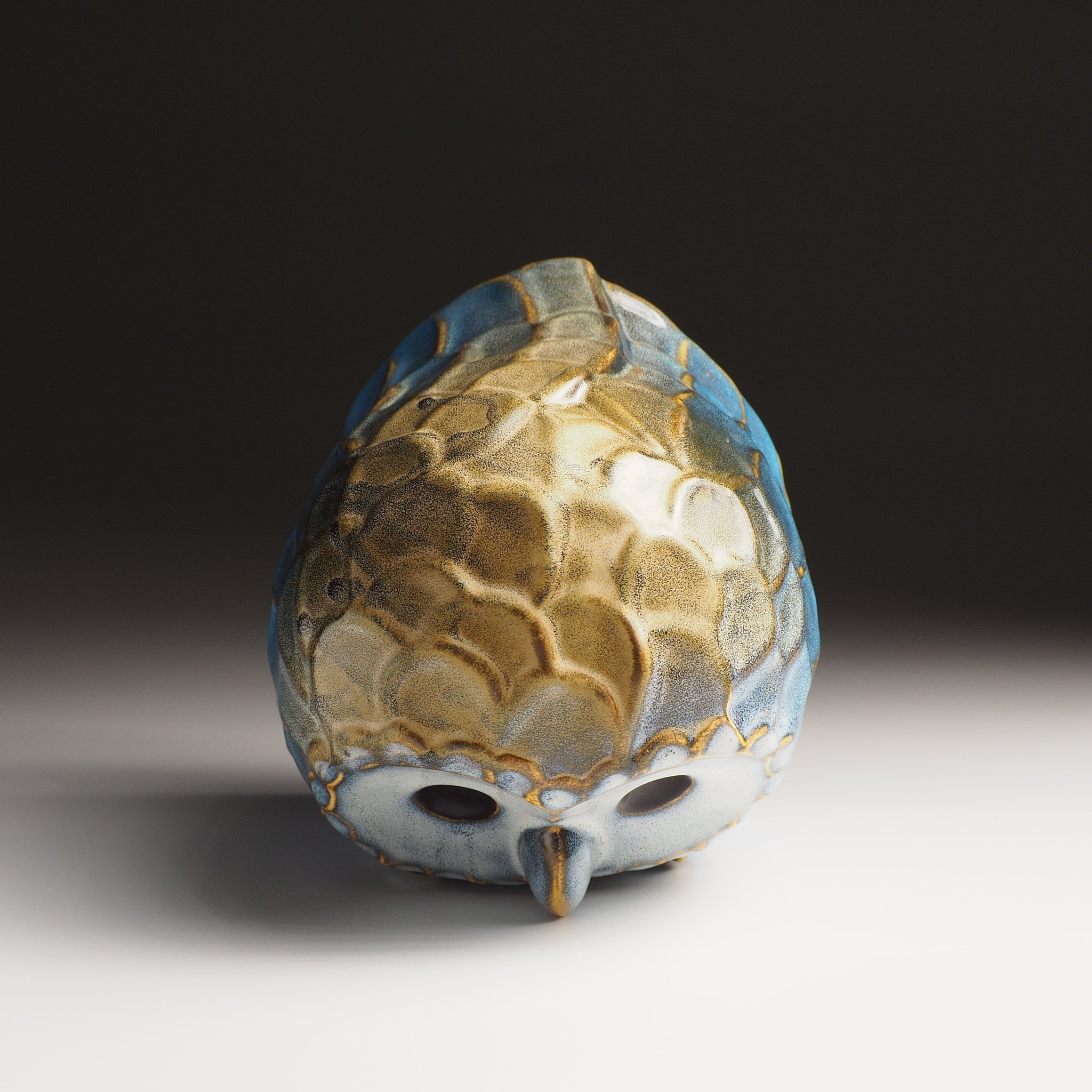 Top view of the large Fukumori ceramic owl figurine by Kazuhiro Kojima, amber and cerulean  glaze on a faded background.