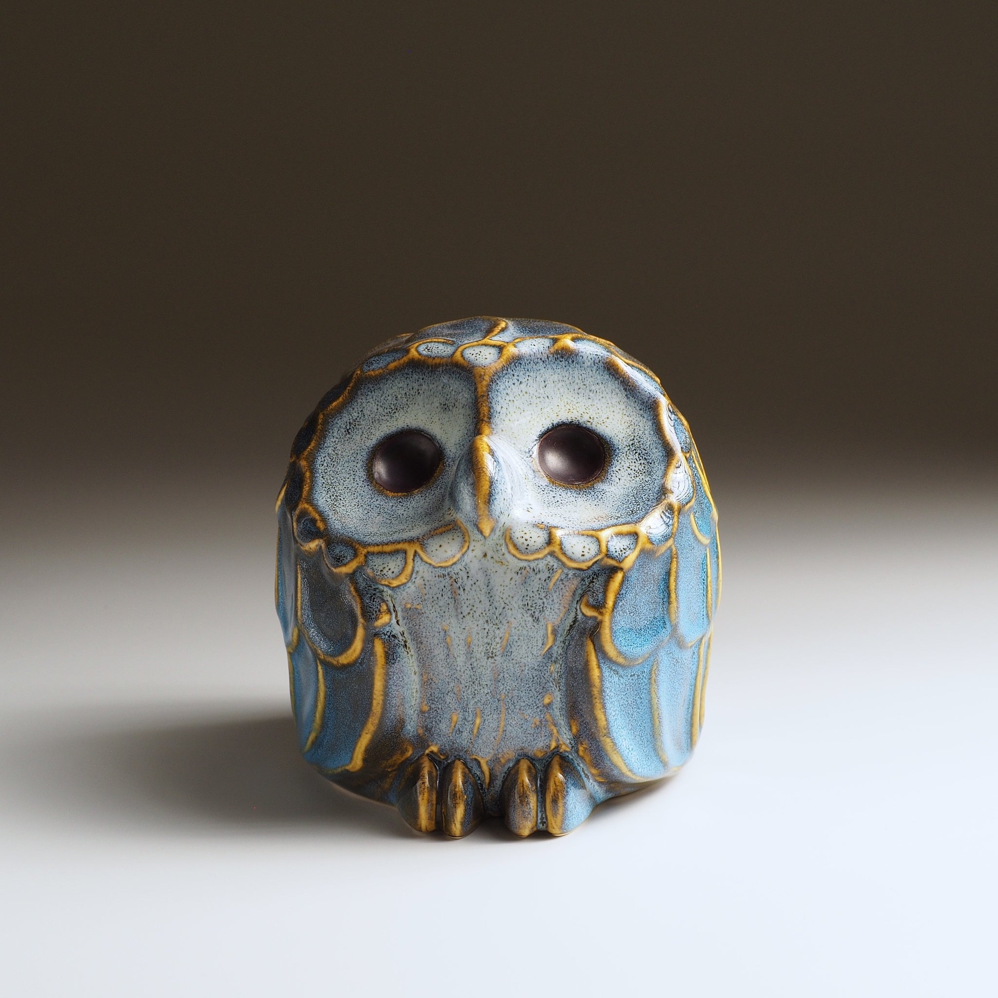 Front view of the Fukumori medium ceramic owl figurine by Kazuhiro Kojima, cerulean blue on faded background.