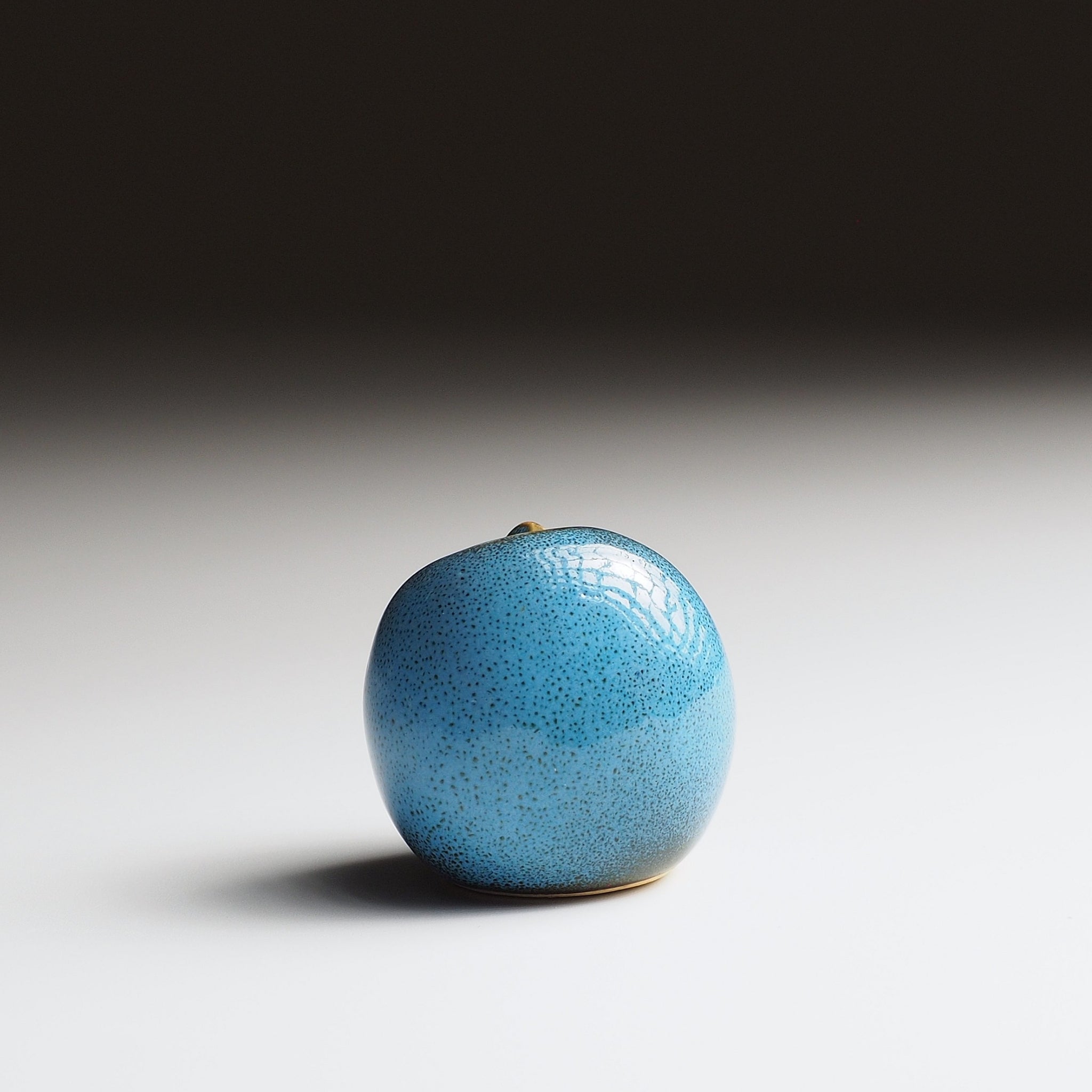 Twilight blue Gofuku ceramic owl figurine, back view showing full rounded body and subtle texture of Nanasai Tenmoku glaze.