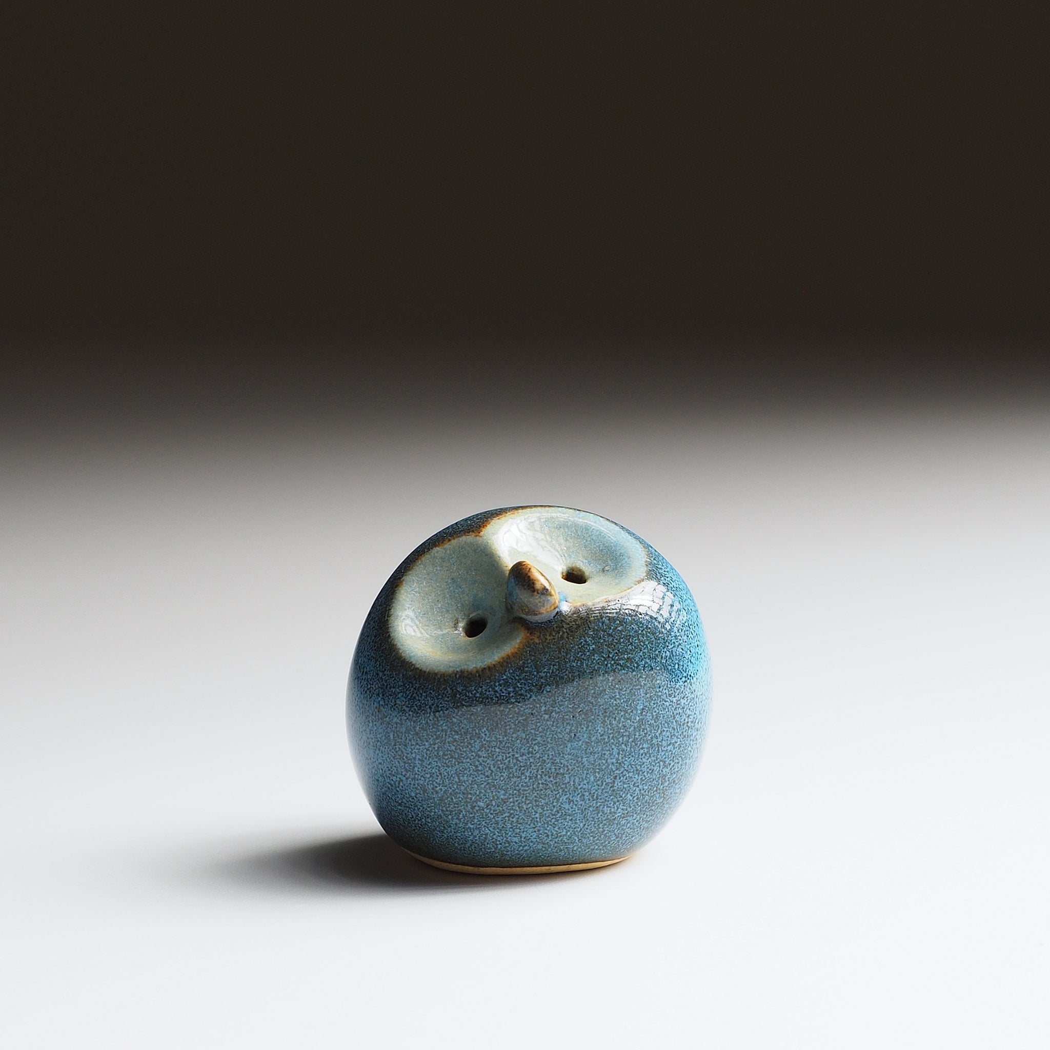 Twilight blue ceramic owl figurine with gold-glazed face and eyes, front view. Handcrafted by Kazuhiro Kojima.