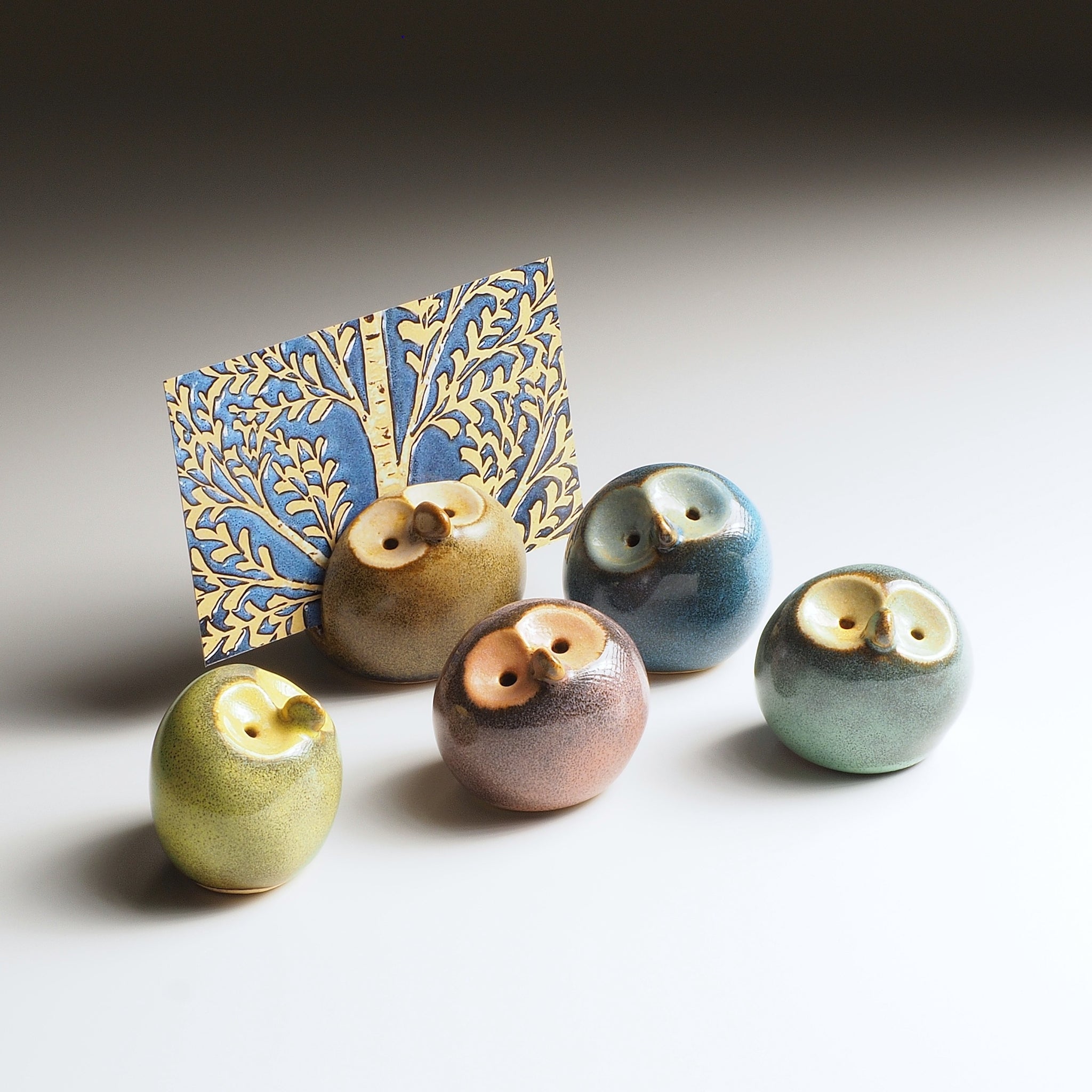 Gofuku set with five ceramic owl figurines and decorative blue and gold butterfly wing backdrop. Handcrafted Japanese pottery.