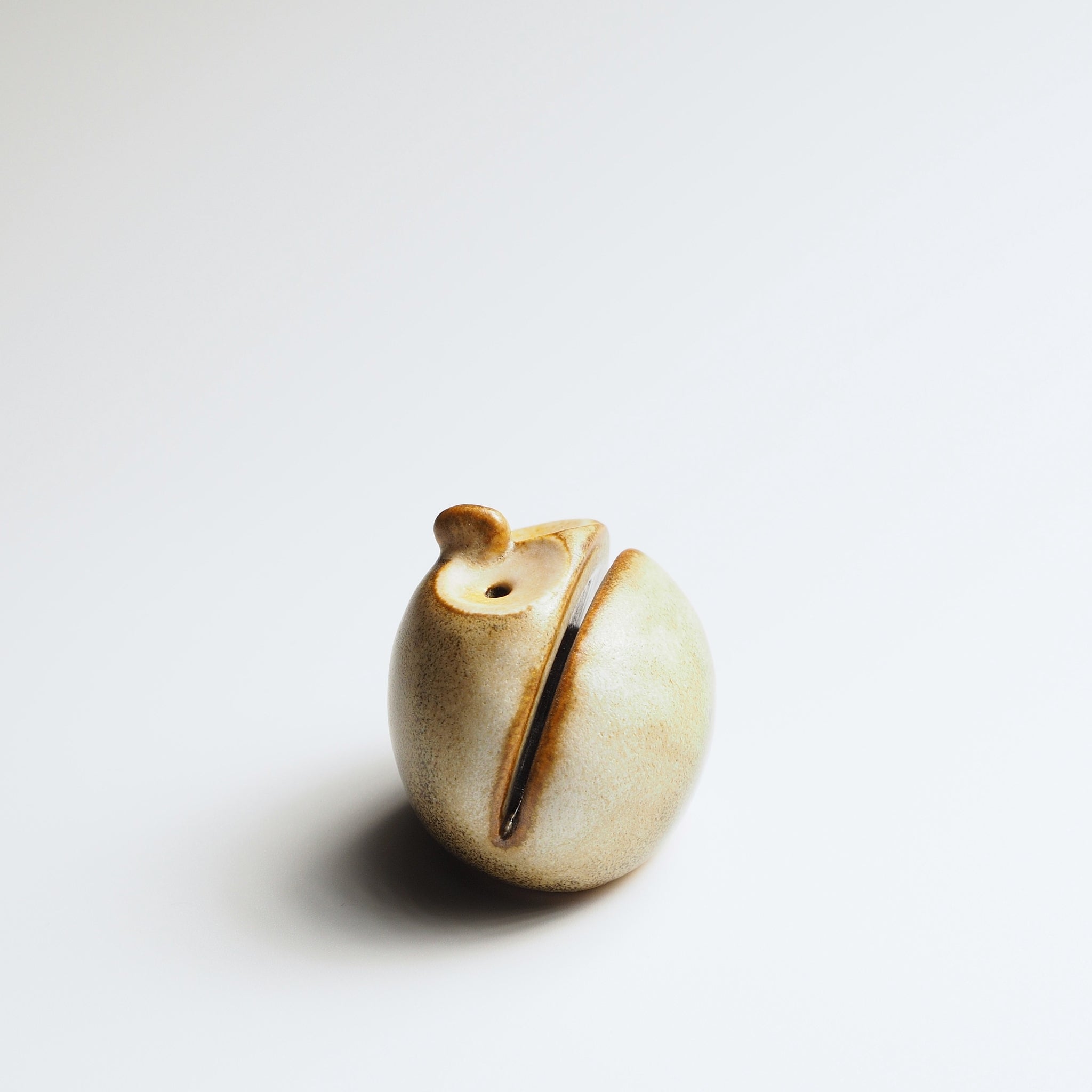 Warm sandstone Gofuku ceramic owl figurine, side profile showing namecard holder slot and minimalist sculptural form.