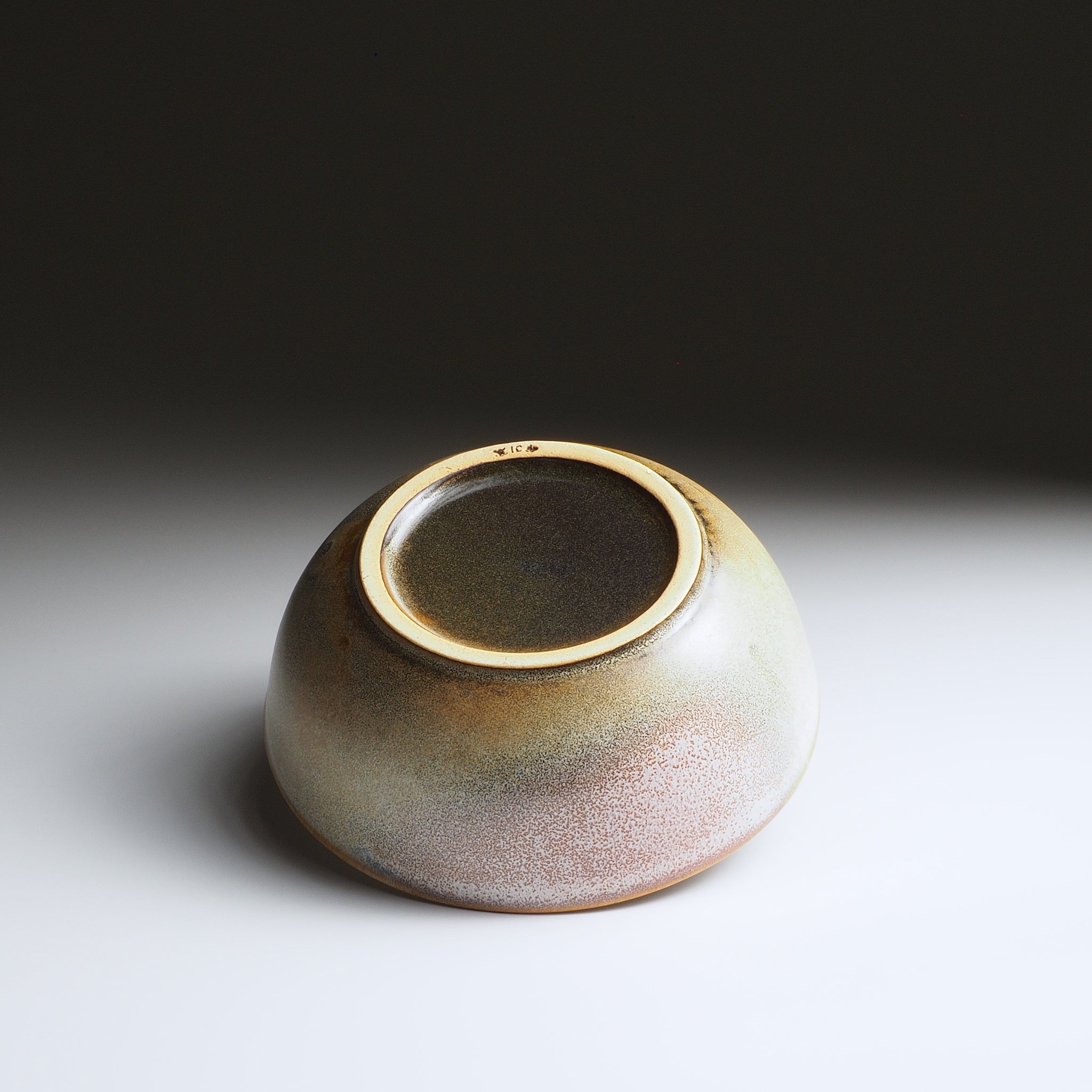 Bottom view of the Harukaze Pink Cherry Blossoms salad bowl by Kazuhiro Kojima on a faded background.