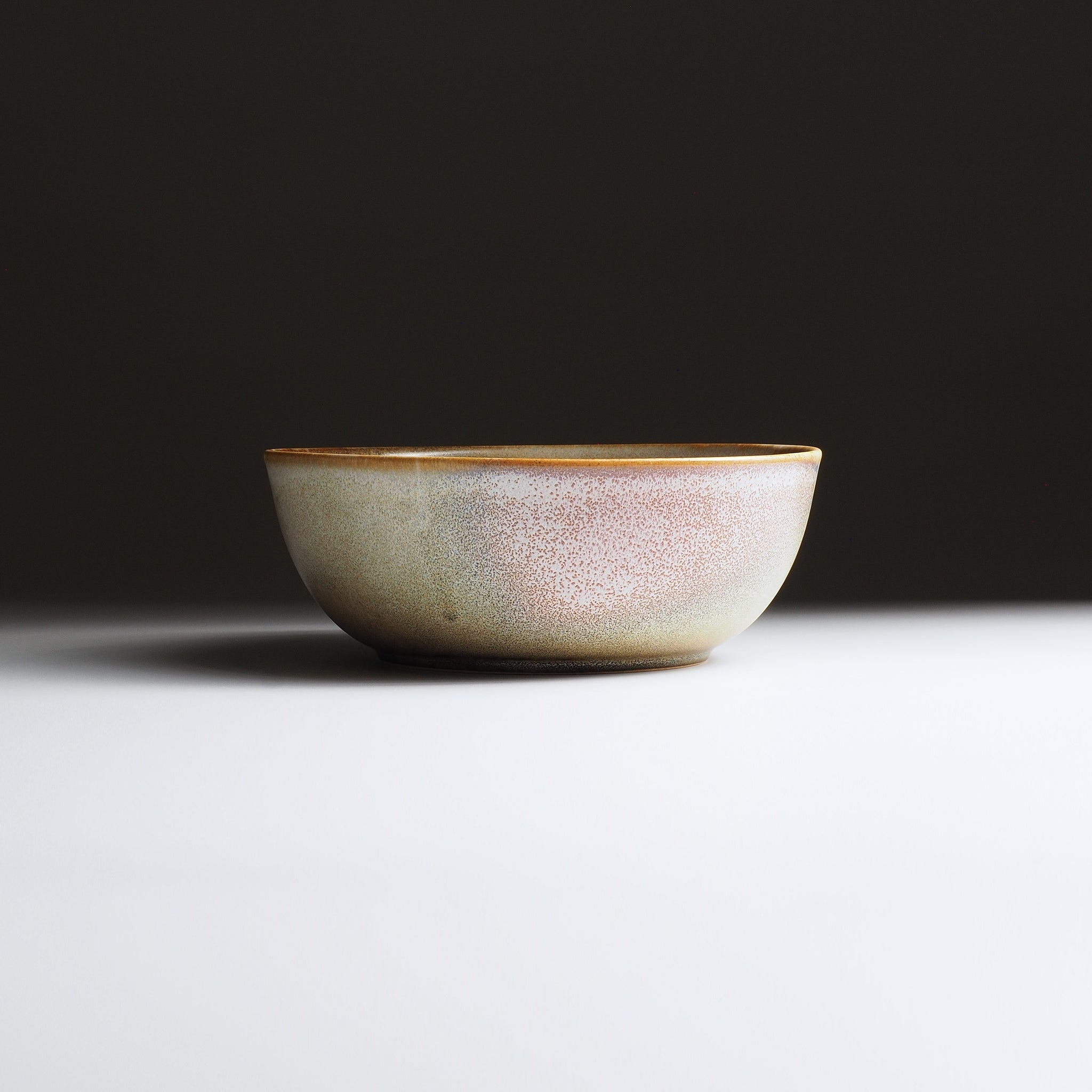 Ceramic bowl with a pink gradient finish on a dark background