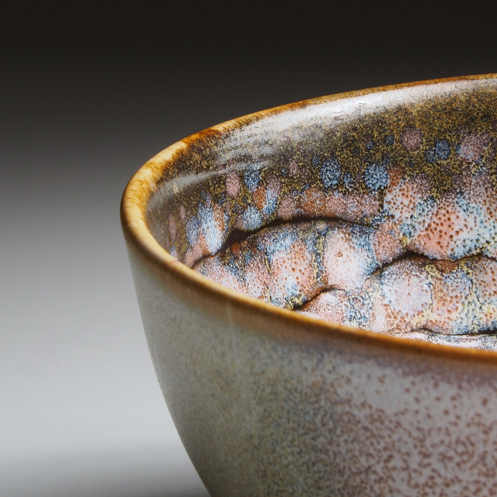 Rim detail of the Harukaze Pink Cherry Blossoms salad bowl by Kazuhiro Kojima on a faded background.