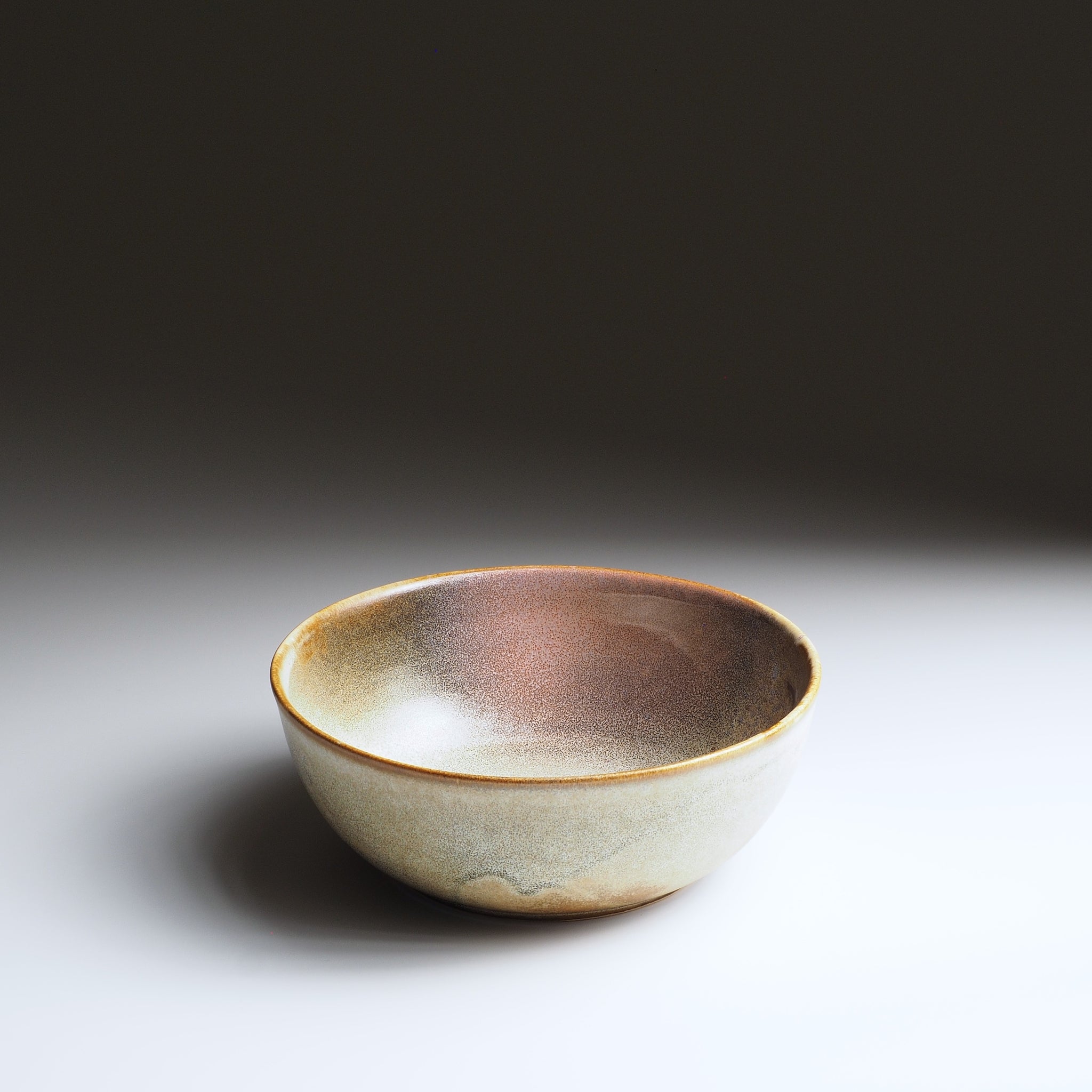 3/4 view of the Harukaze Pink Cherry Blossoms salad bowl by Kazuhiro Kojima on a faded background.