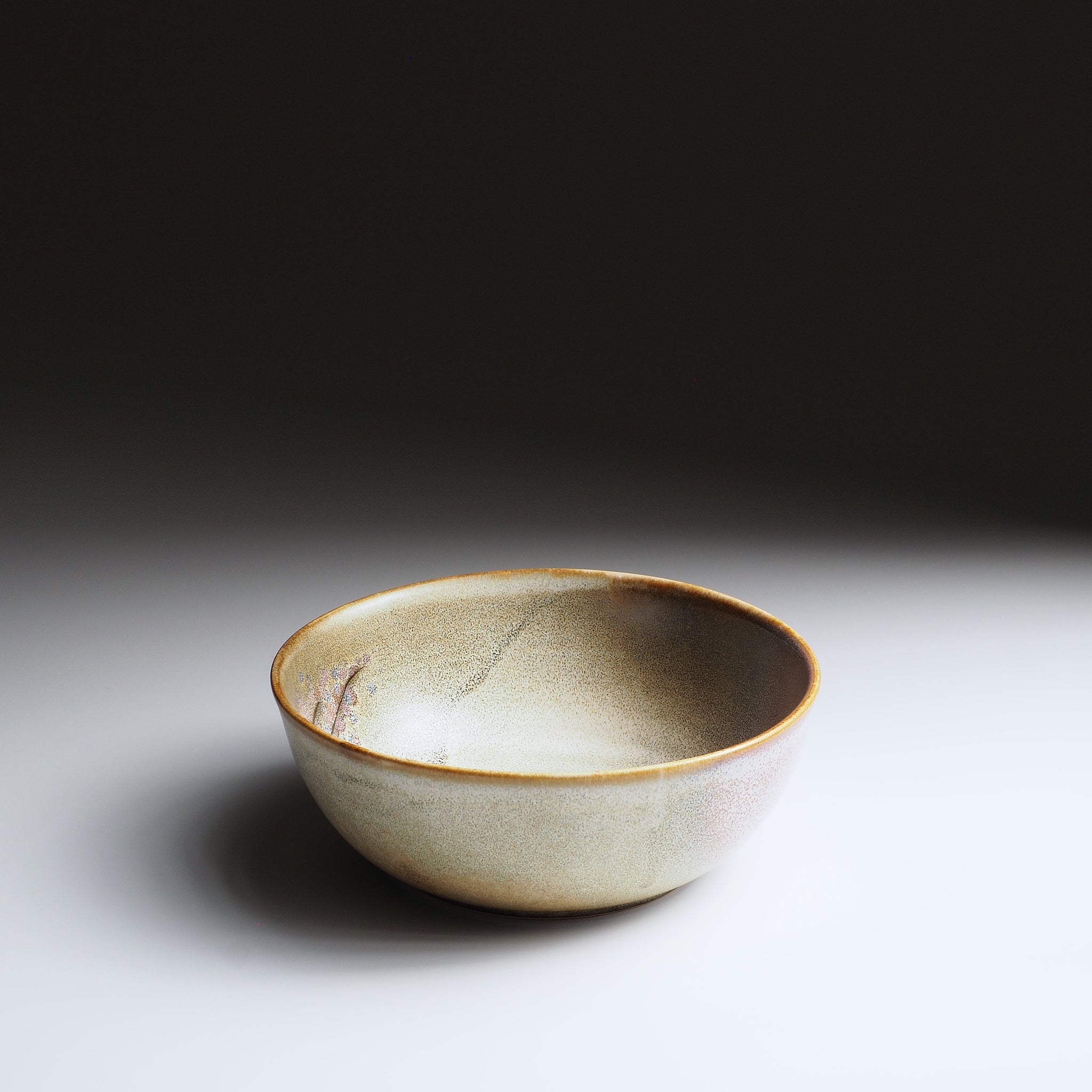 3/4 front view of the Harukaze Pink Cherry Blossoms salad bowl by Kazuhiro Kojima on a faded background.