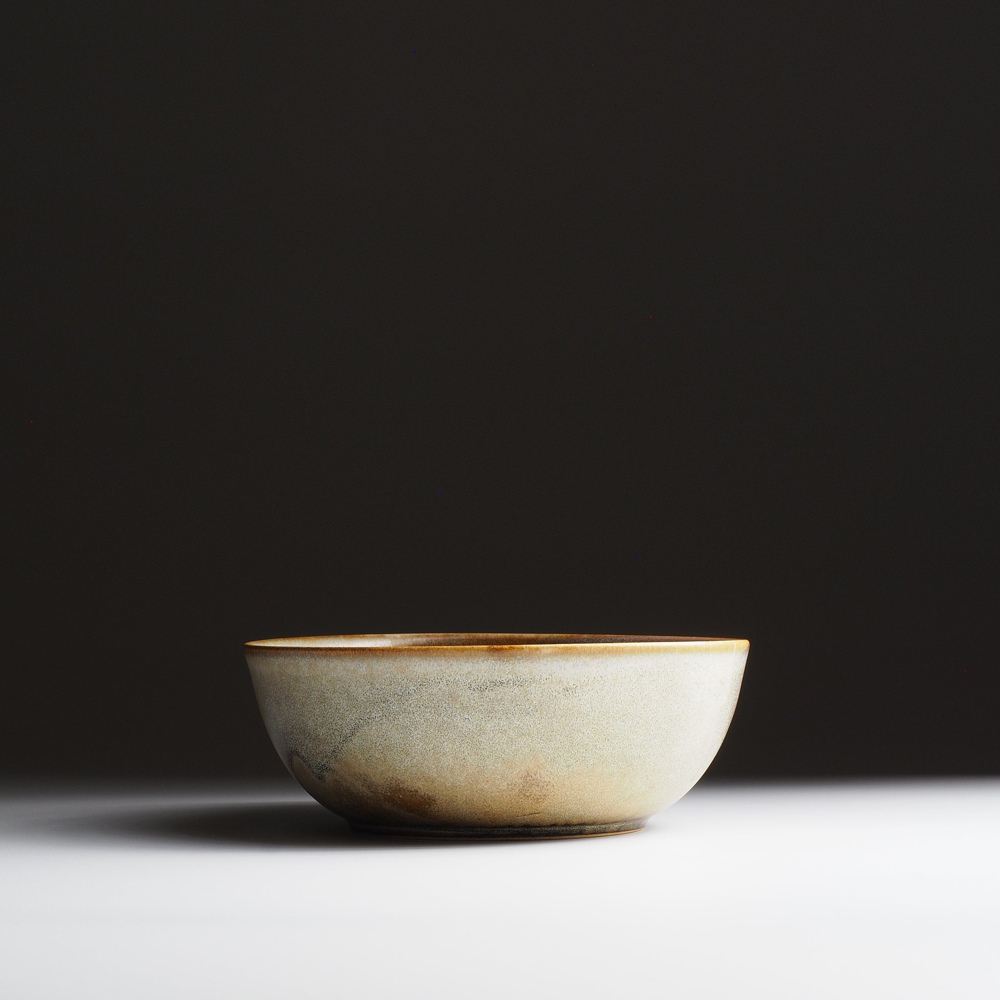 Full frontal view of the Harukaze Pink Cherry Blossoms salad bowl by Kazuhiro Kojima on a faded background.