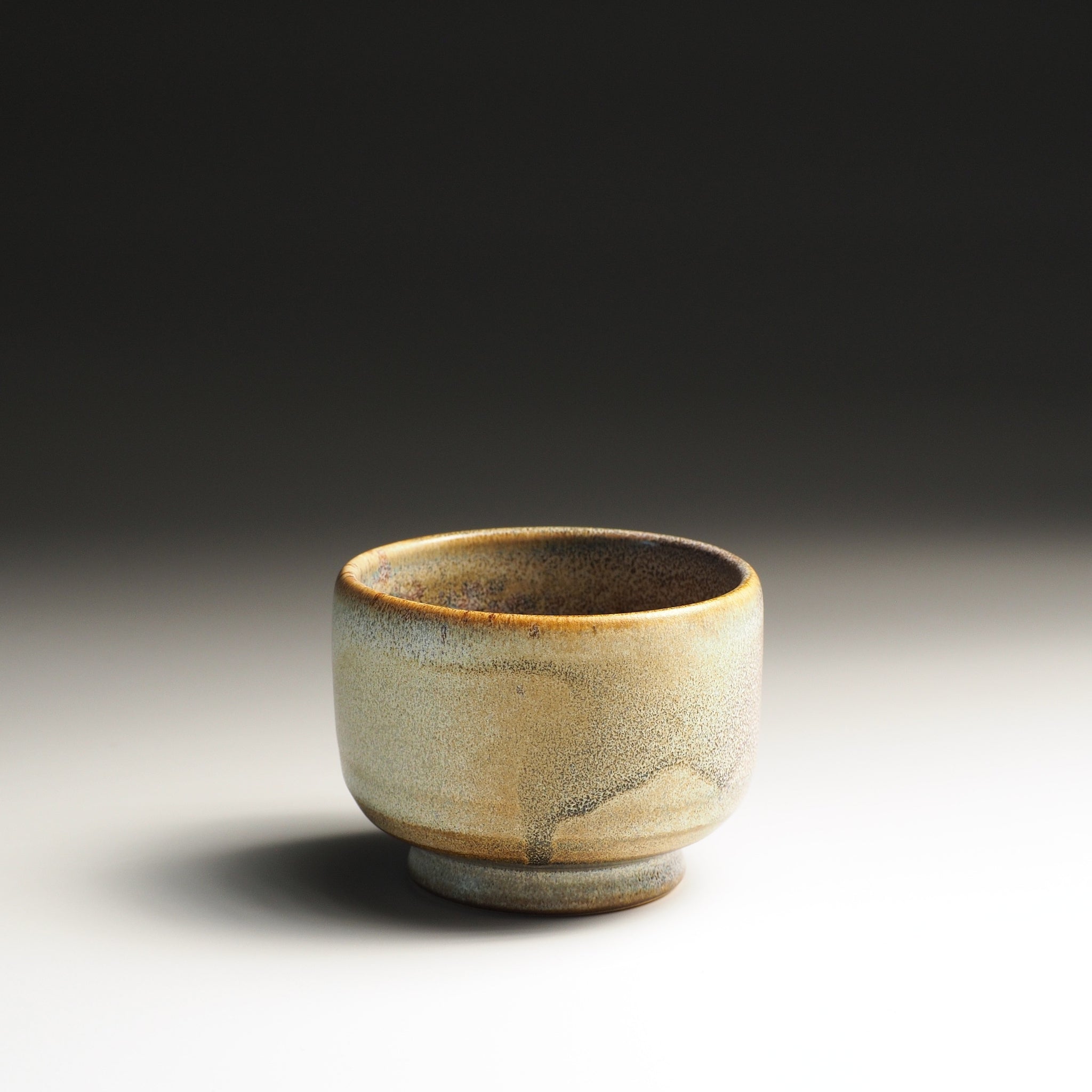 Japanese Ceramic yunomi teacup with a textured surface on a studio gradient background