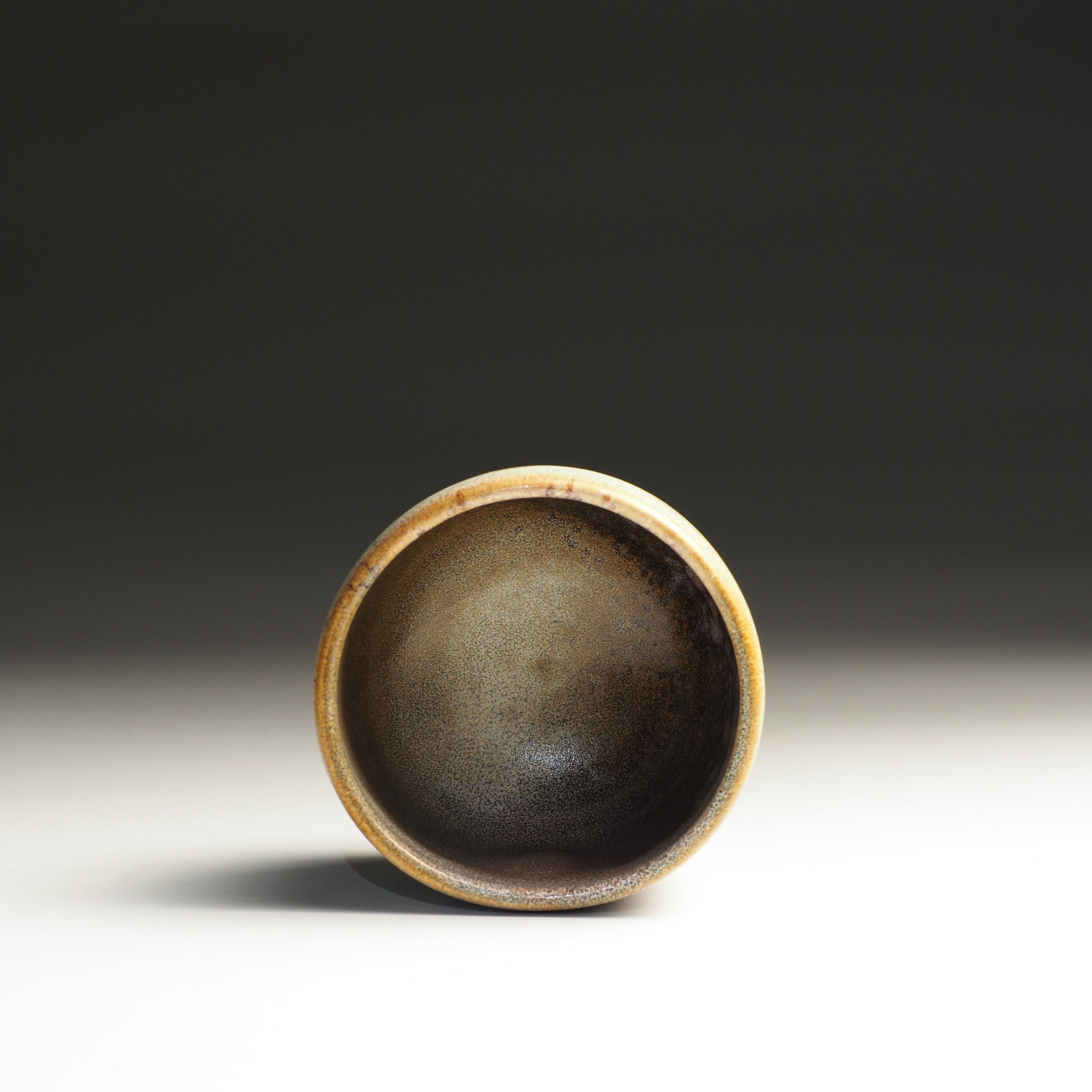Inside view of a Japanse ceramic teacup on a studio gradient background