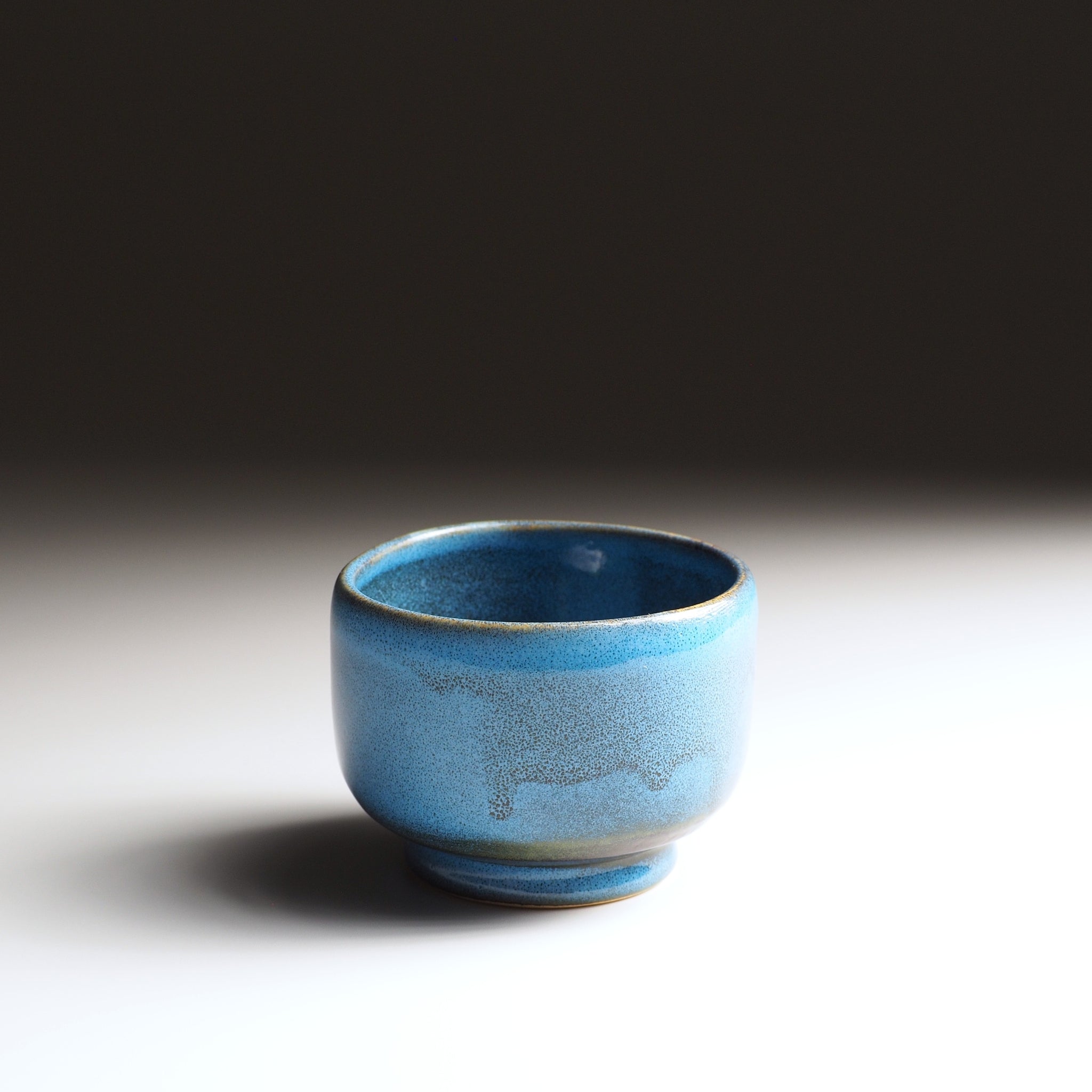 Front view of the Maru Komorebi Yunomi blue teacup on a faded background.