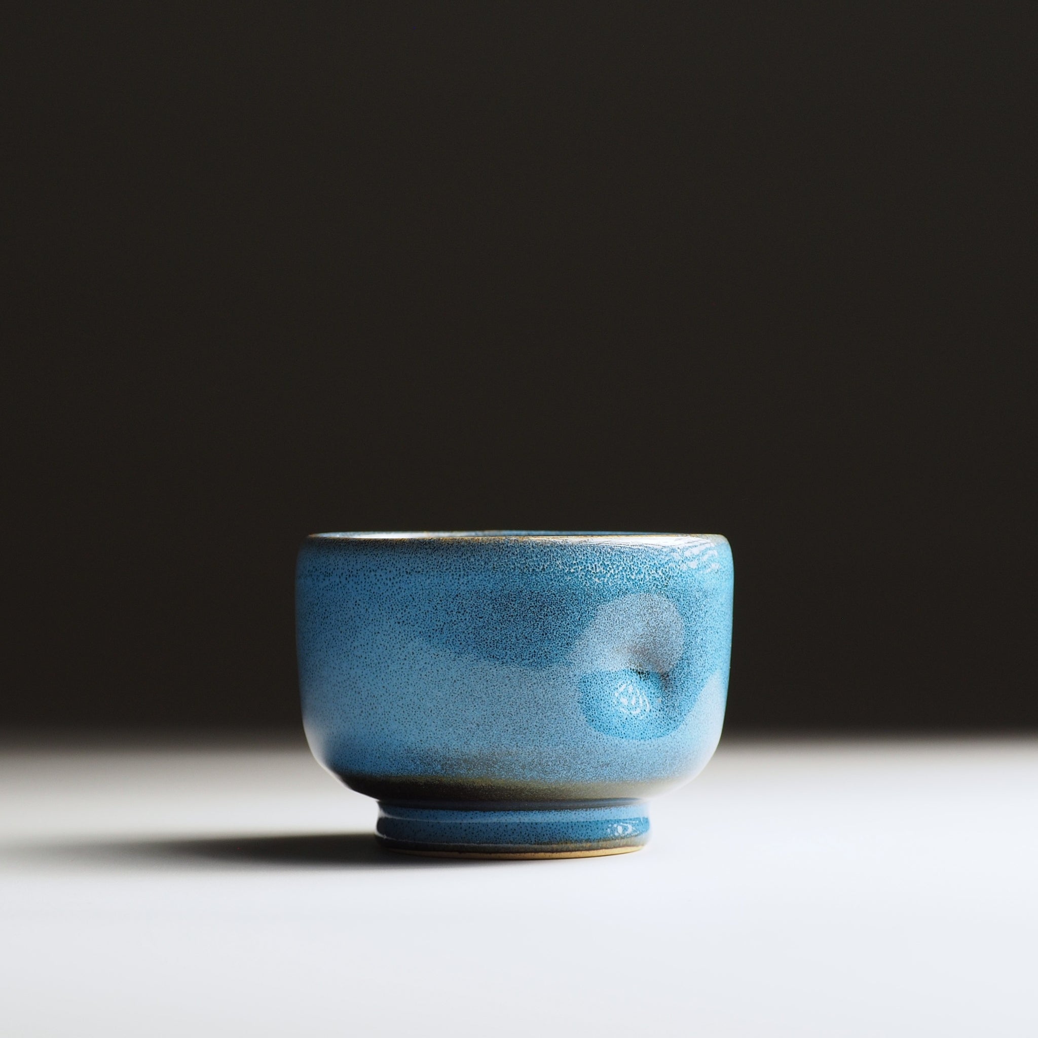 Full frontal view of the Maru Komorebi Yunomi blue teacup on a faded background.
