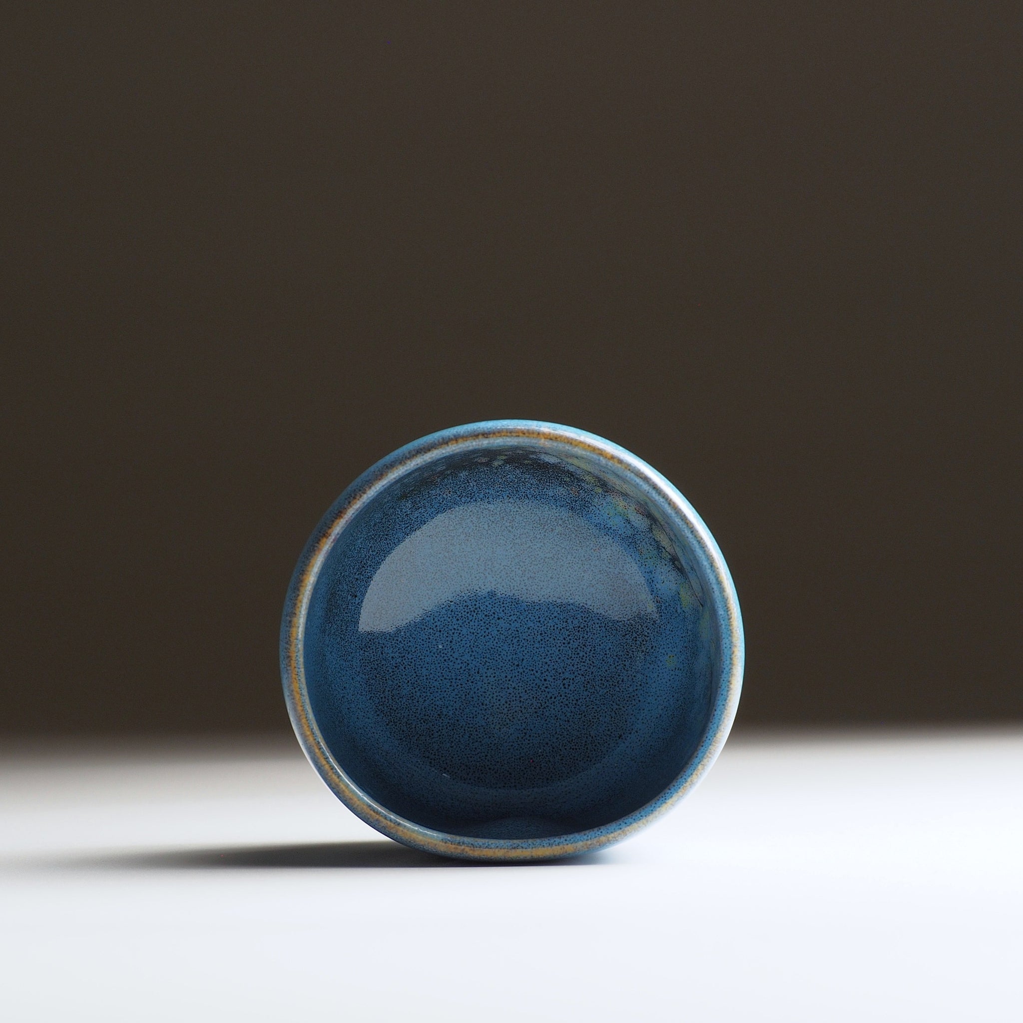Inside view of the Maru Komorebi Yunomi blue teacup on a faded background.