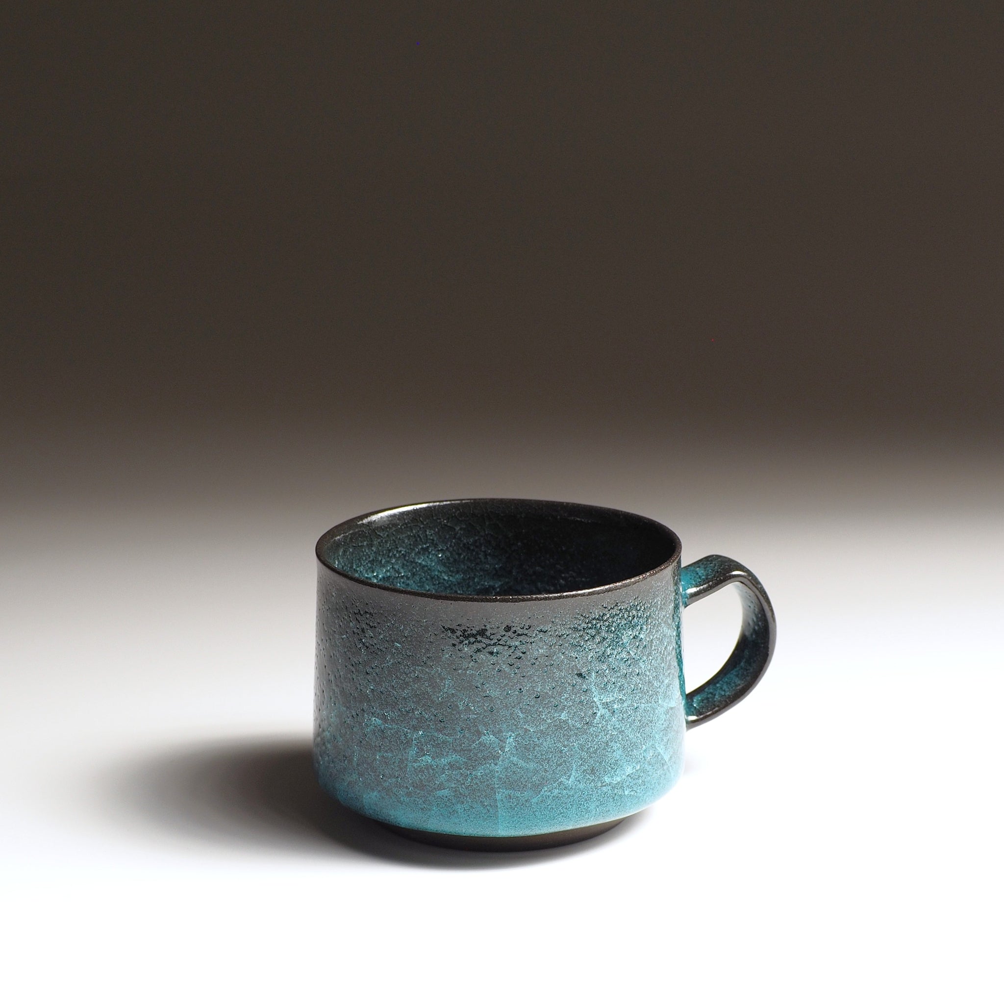 Handcrafted Japanese pottery coffee cup with kannyū ceramic crazing glaze, emerald green and deep obsidian, Taichi Kawai, Usurai Pottery Kyoto
