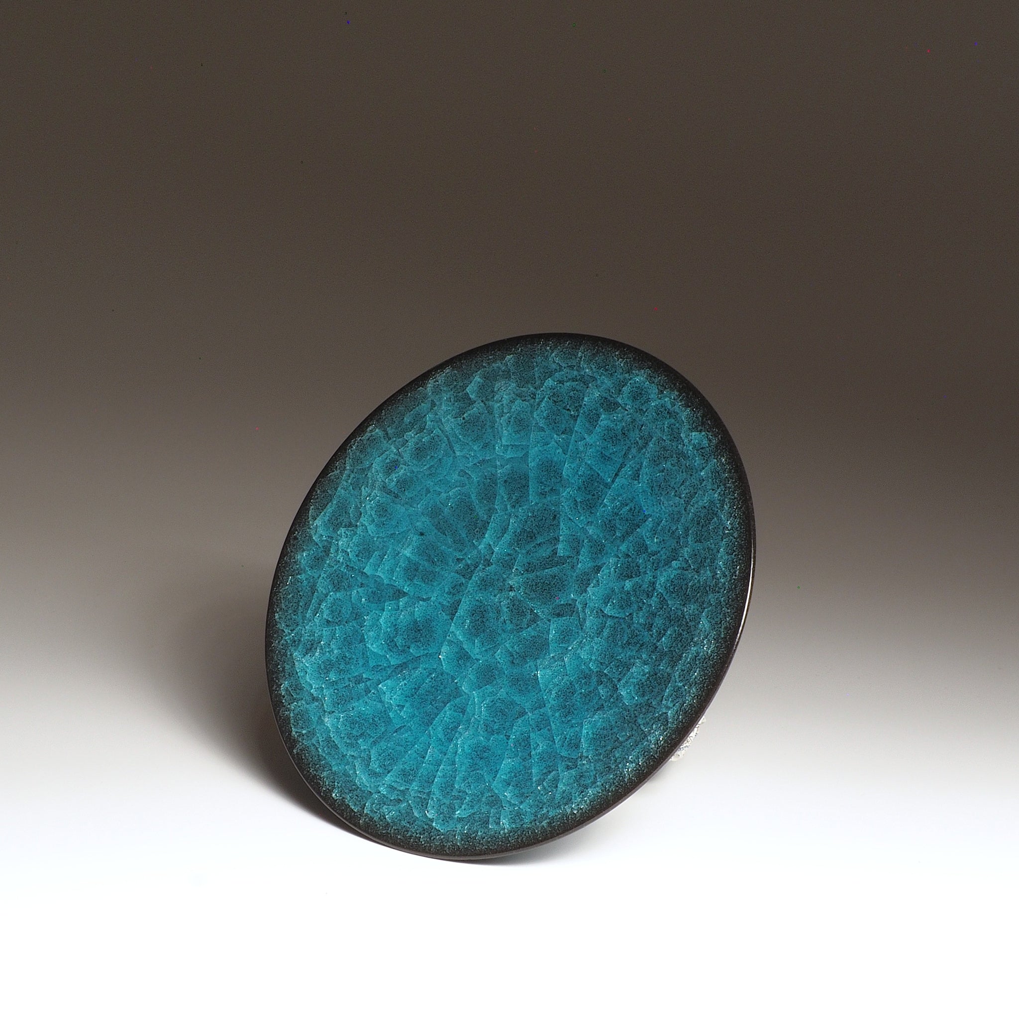Ceramic Japanese plate with textured emerald green glaze on a gradient background